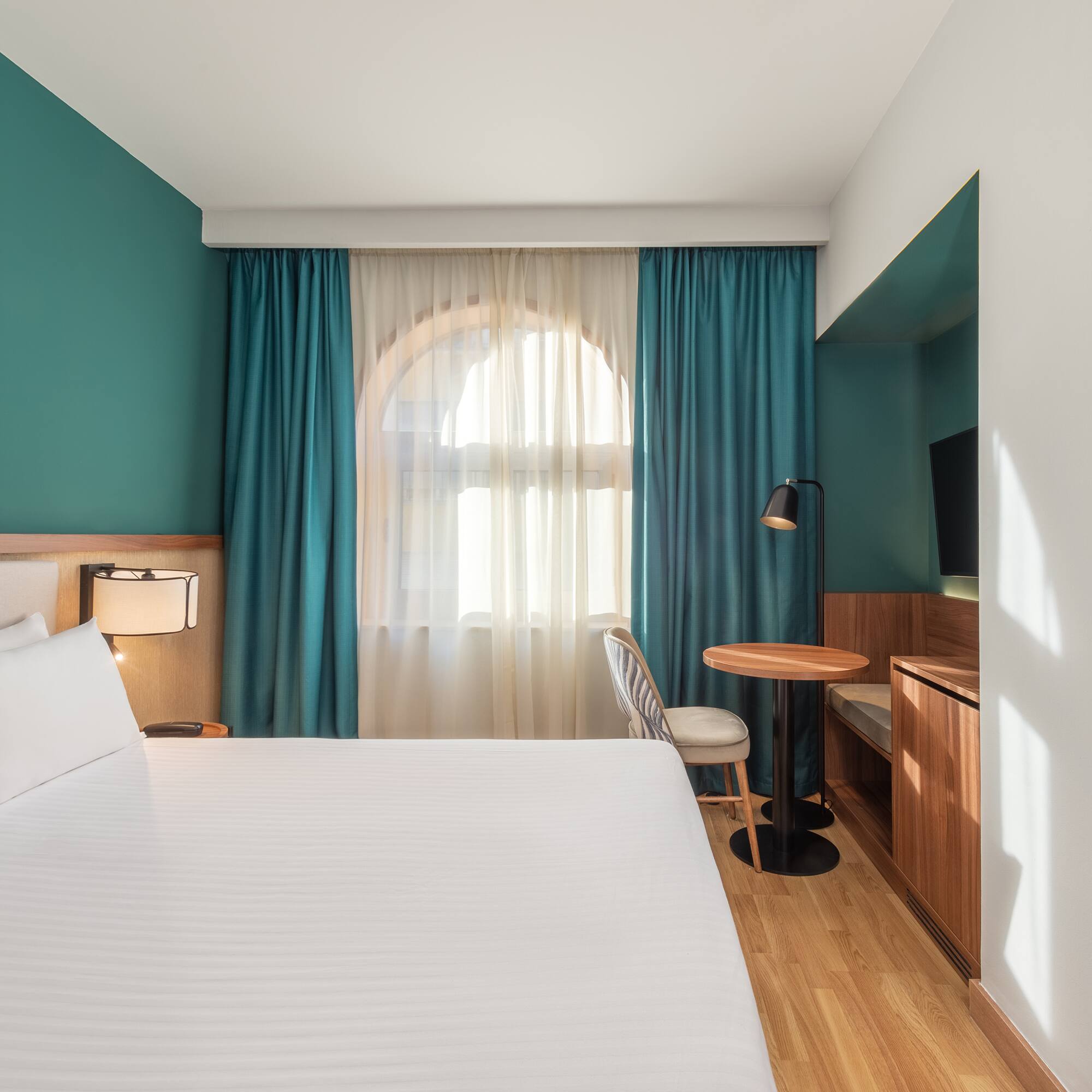 a room with a bed and a table and chair