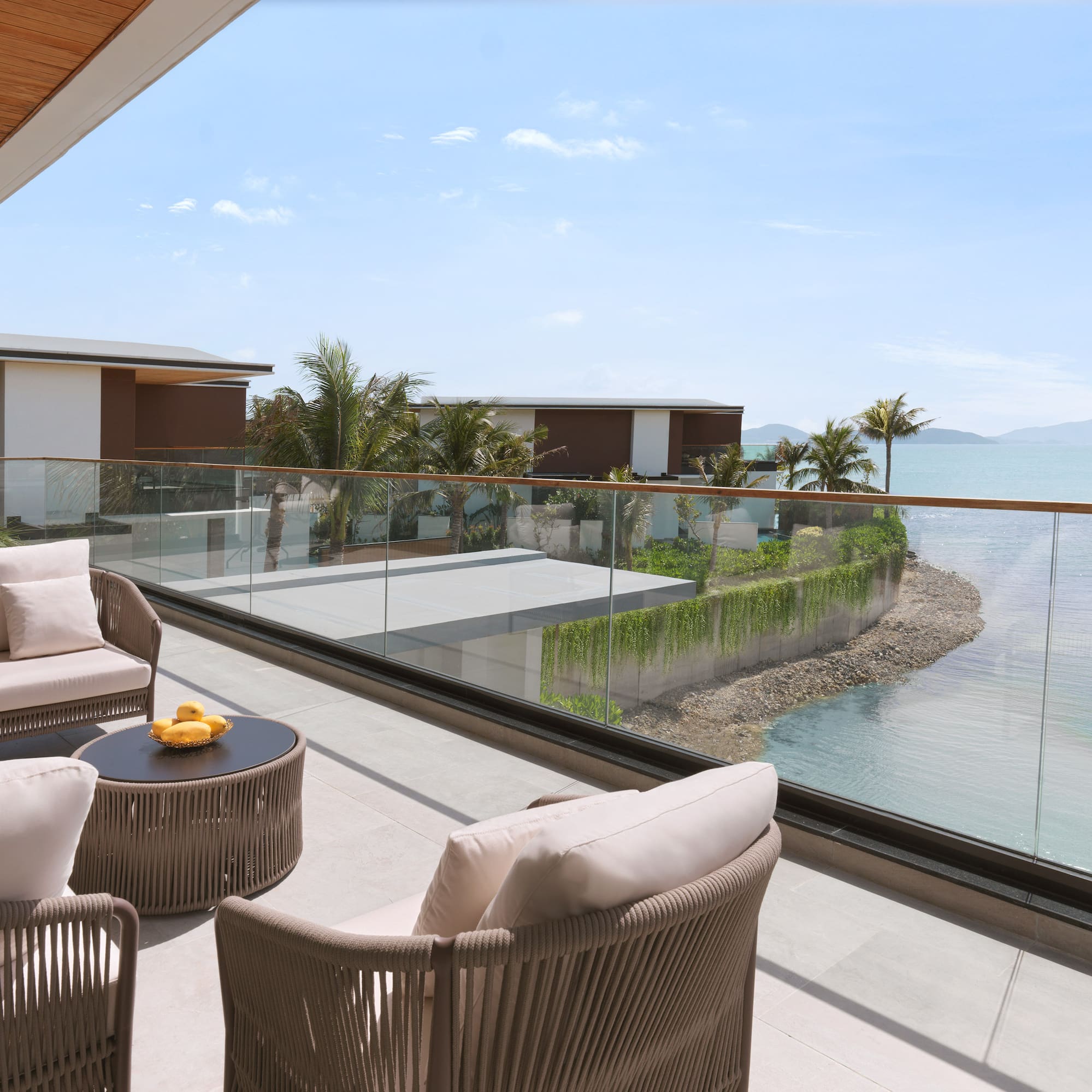 a patio with chairs and a table overlooking a body of water