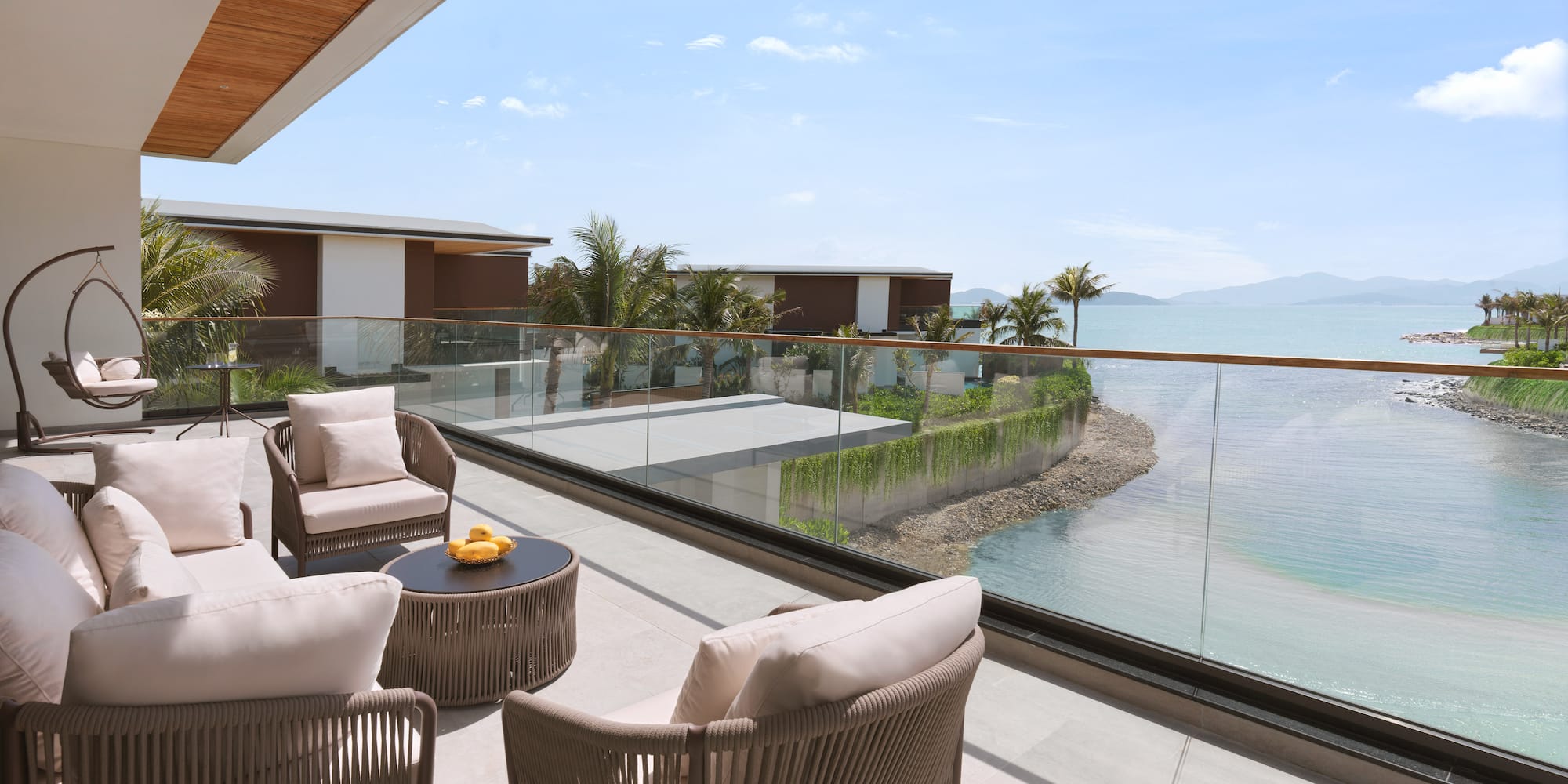 a patio with chairs and a table overlooking a body of water