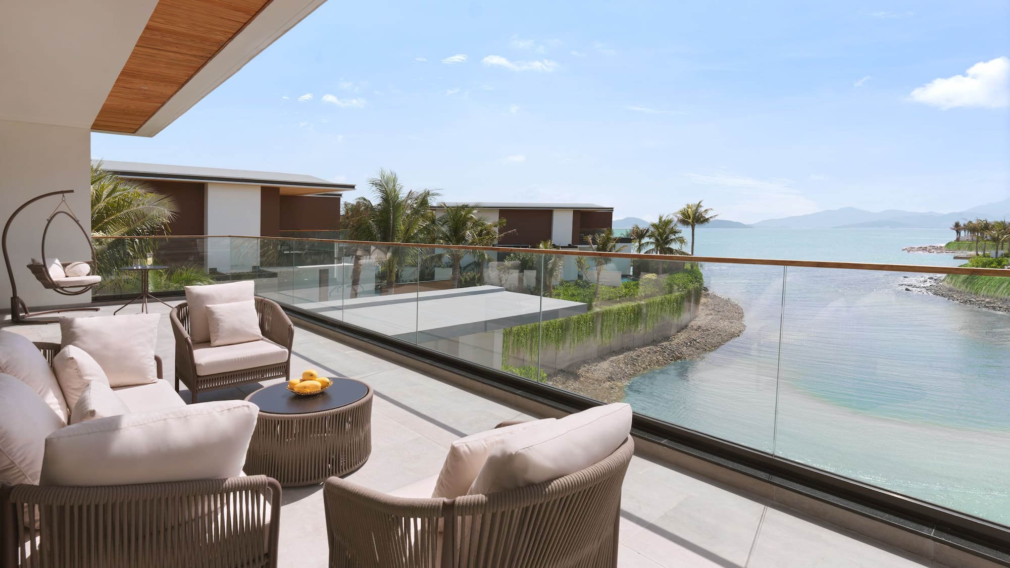 a patio with chairs and a table overlooking a body of water