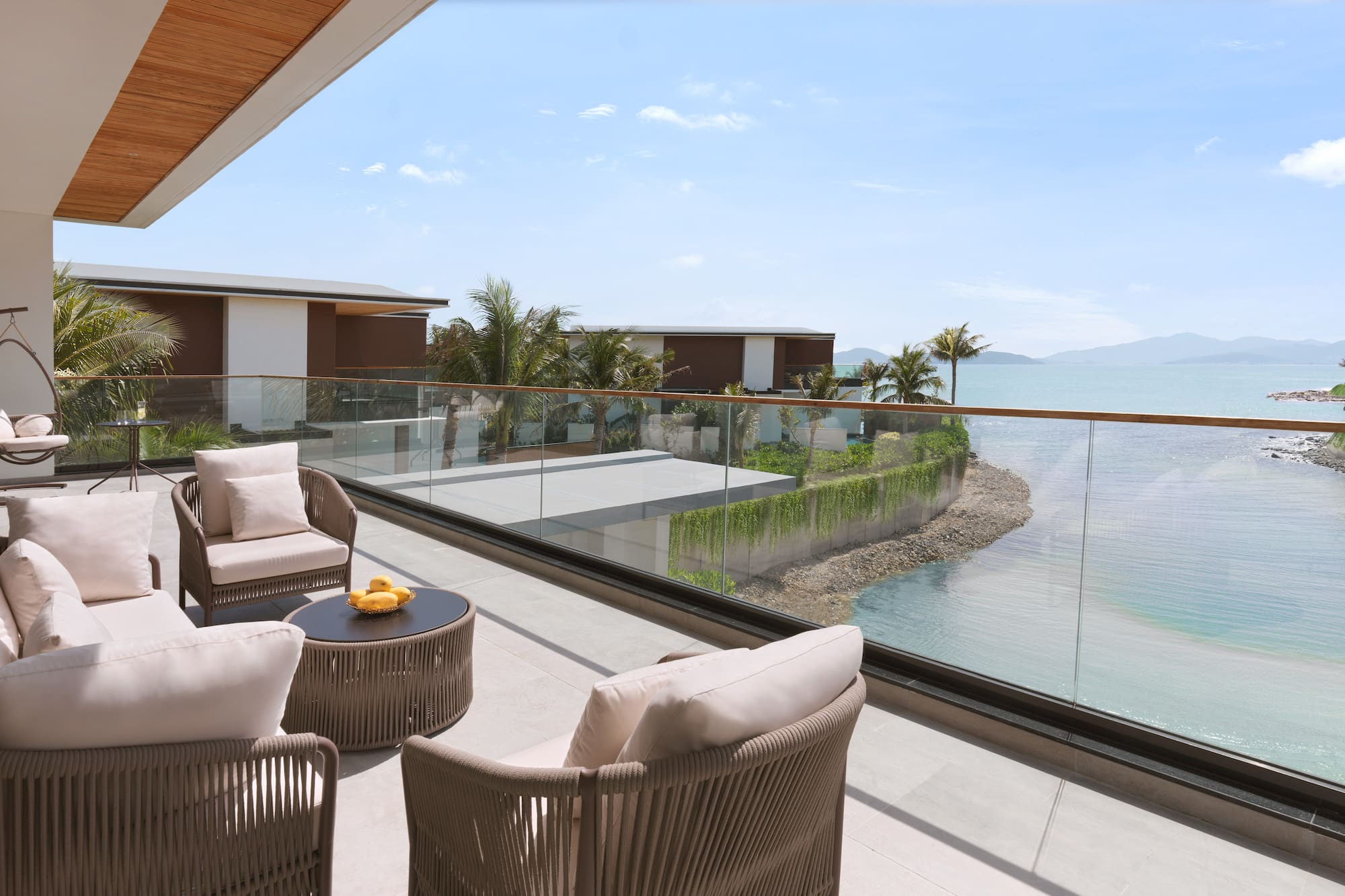 a patio with chairs and a table overlooking a body of water