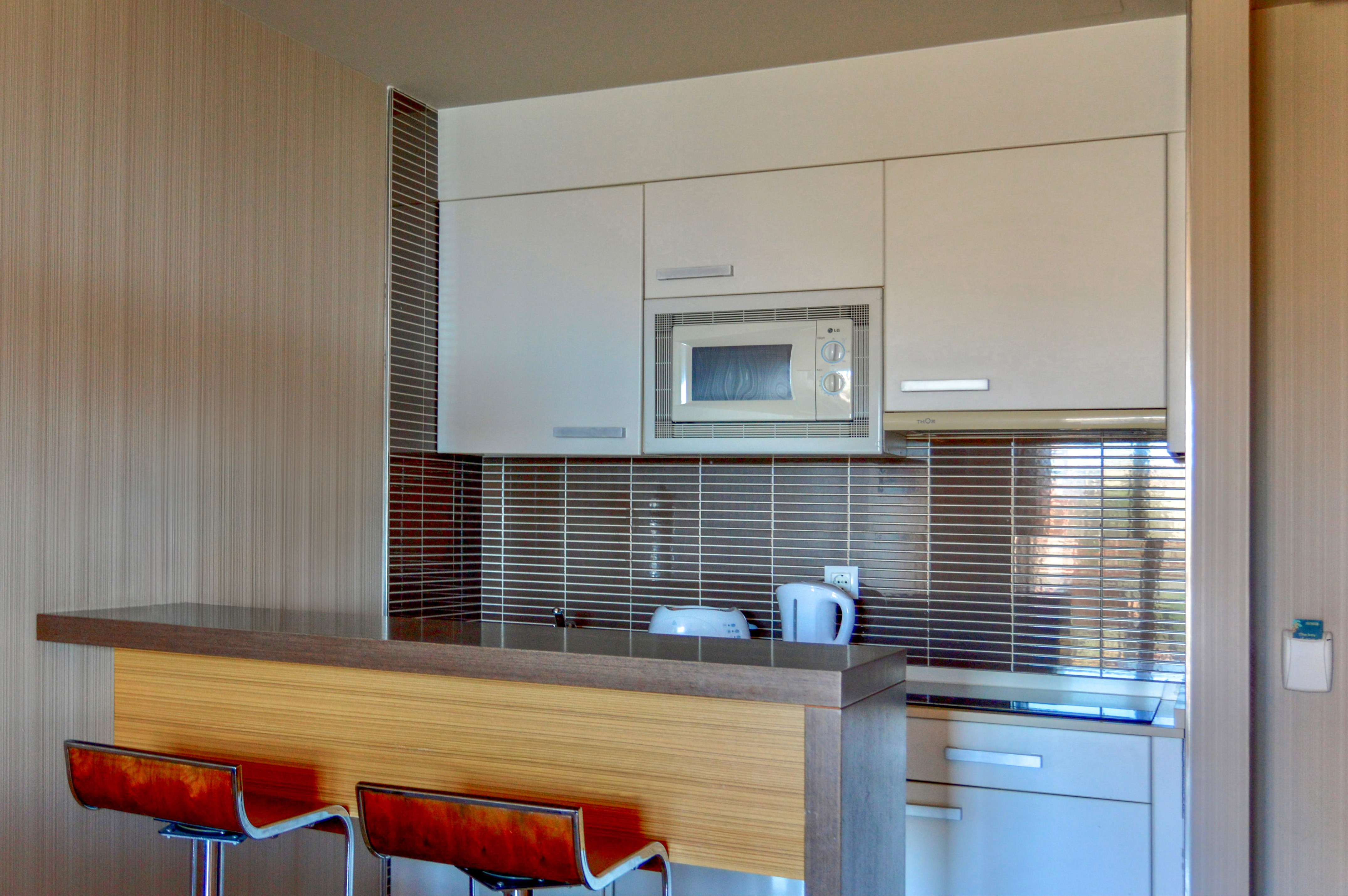 a kitchen with a microwave oven and bar stools