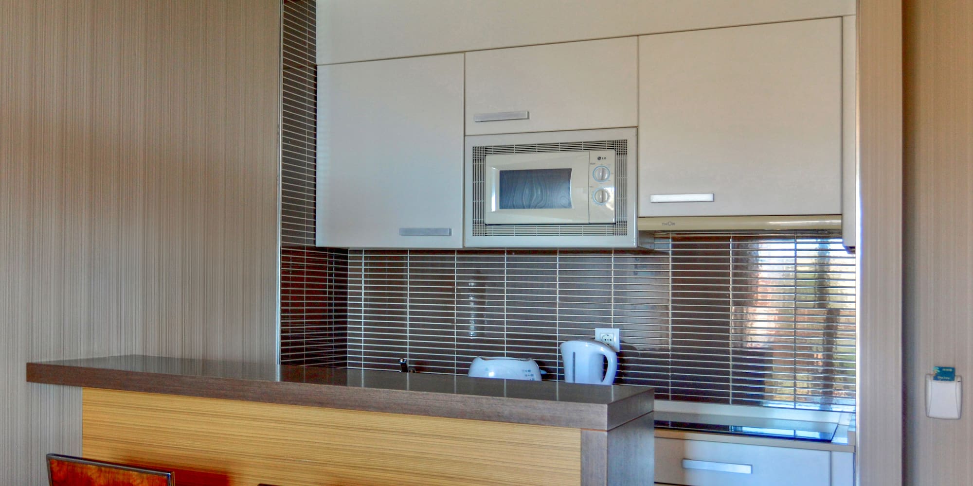 a kitchen with a microwave oven and bar stools