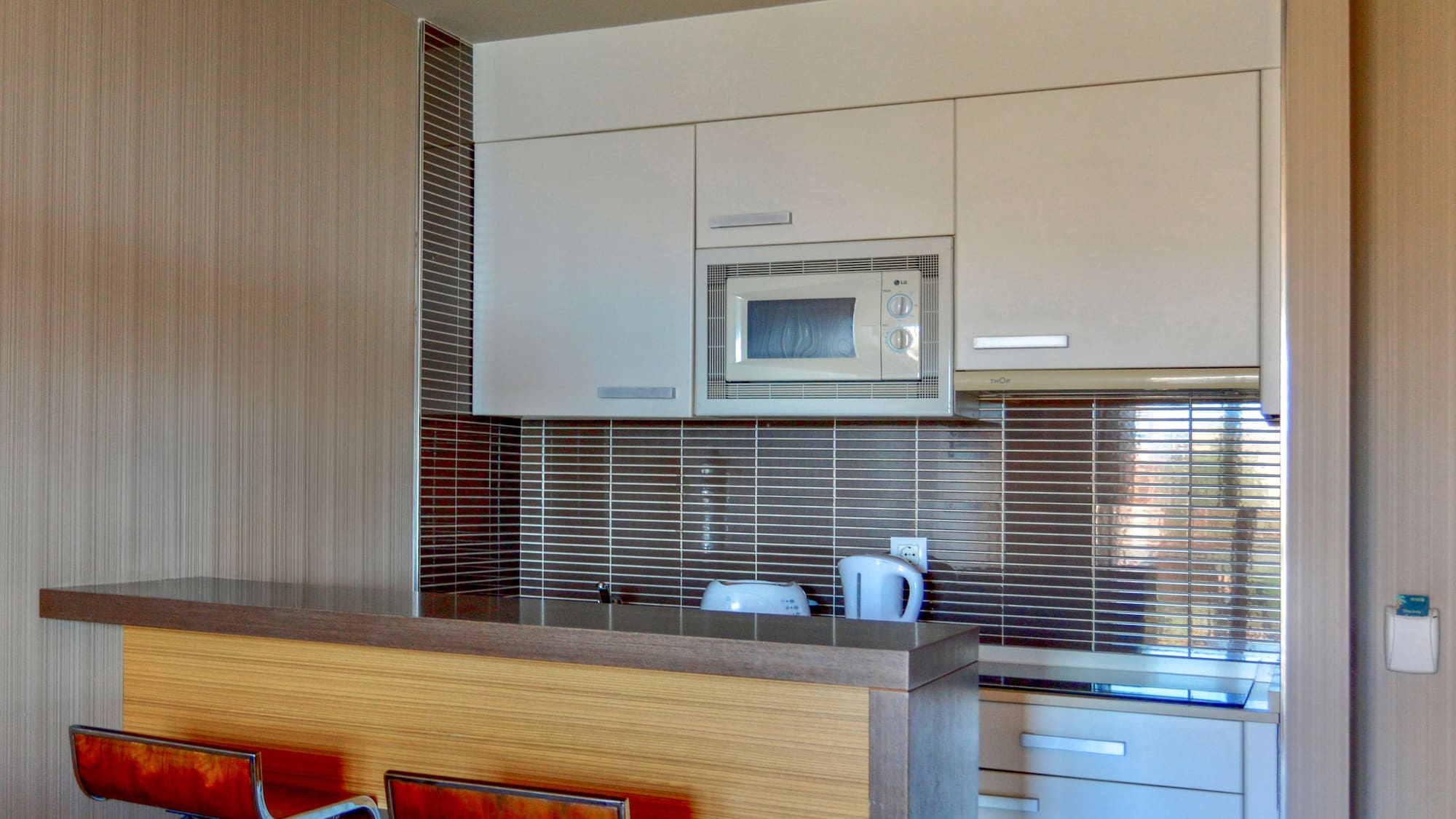 a kitchen with a microwave oven and bar stools