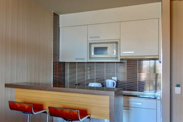 a kitchen with a microwave oven and bar stools