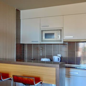 a kitchen with a microwave oven and bar stools