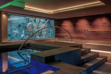 a pool with a staircase and a glass wall