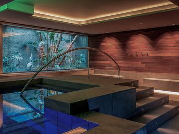 a pool with a staircase and a glass wall