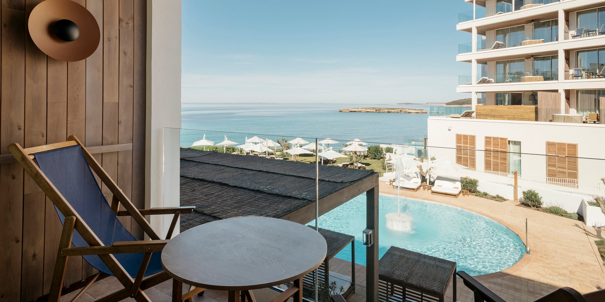 a chair and table with a pool in the background