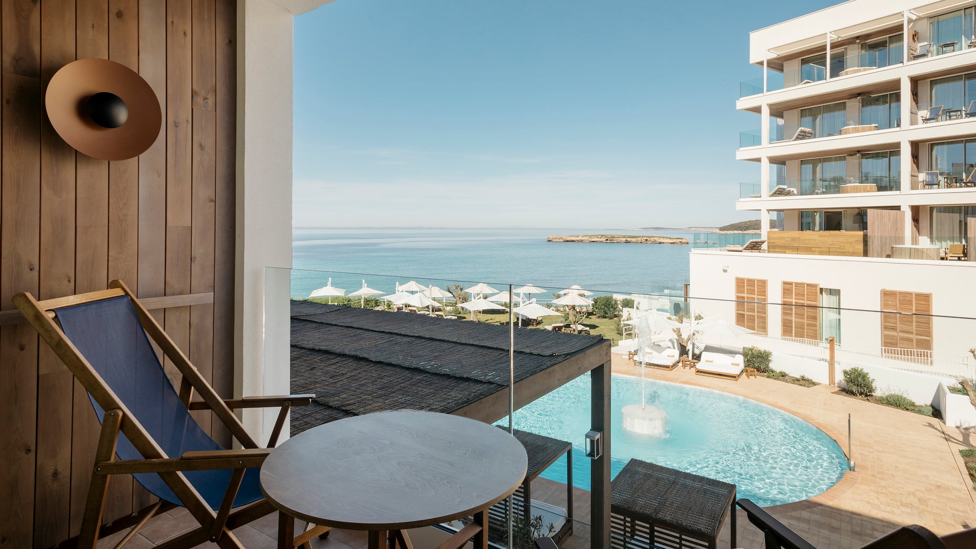 a chair and table with a pool in the background