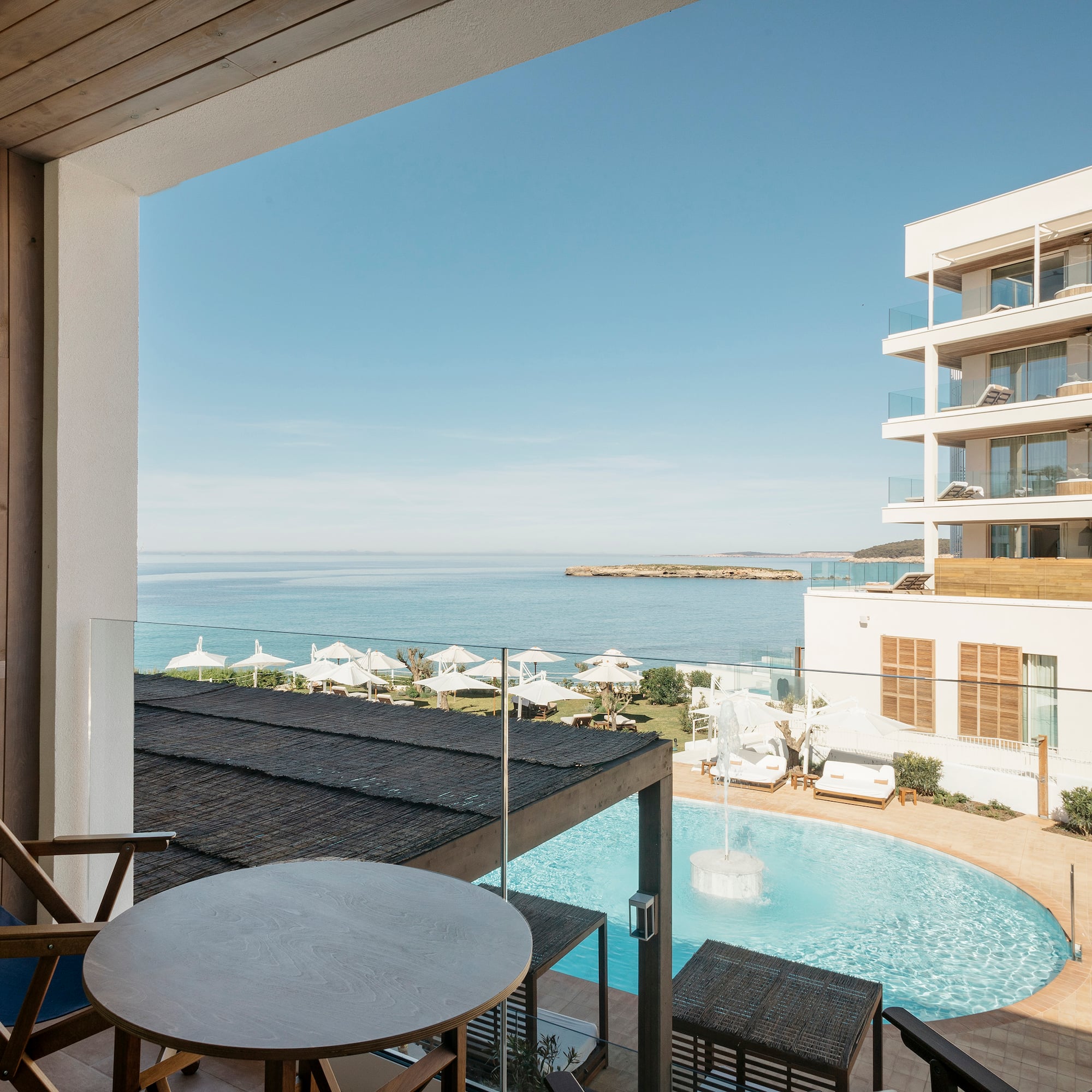a chair and table with a pool in the background