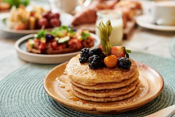 a stack of pancakes with berries on top