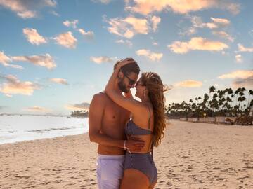 a man and woman hugging on a beach