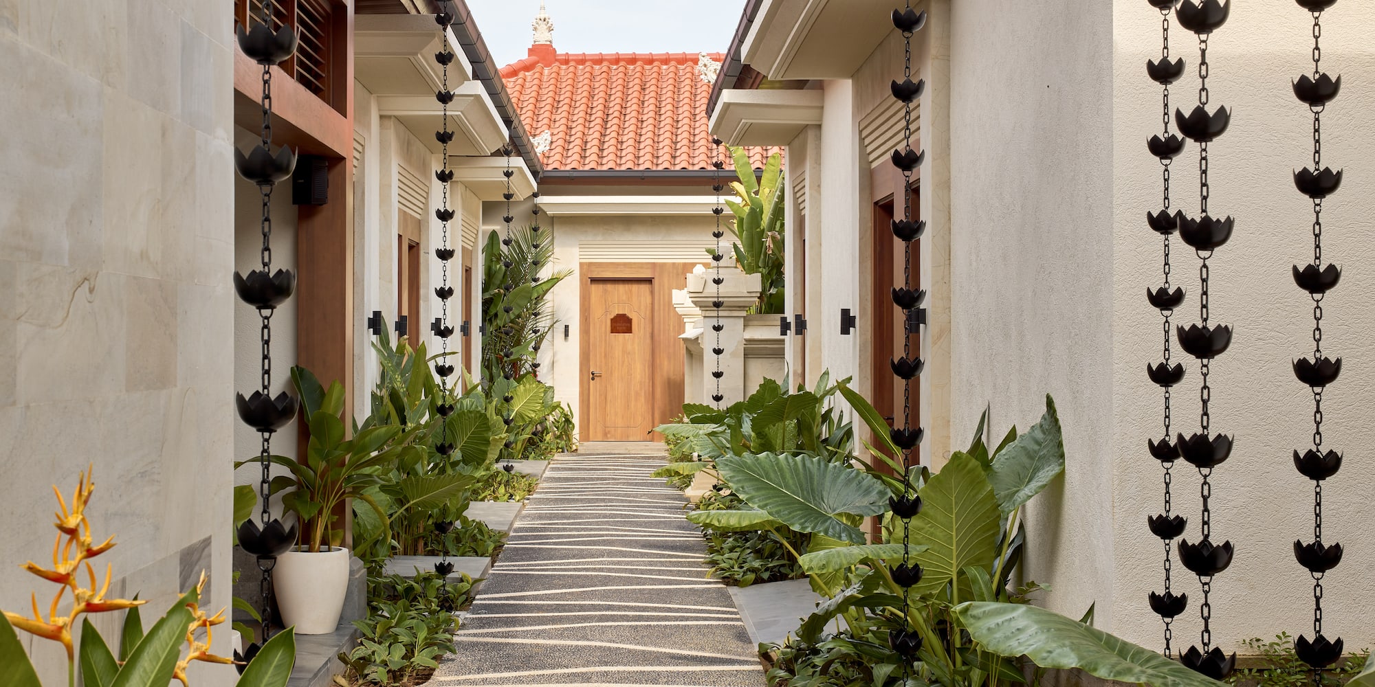 a walkway between two buildings with plants