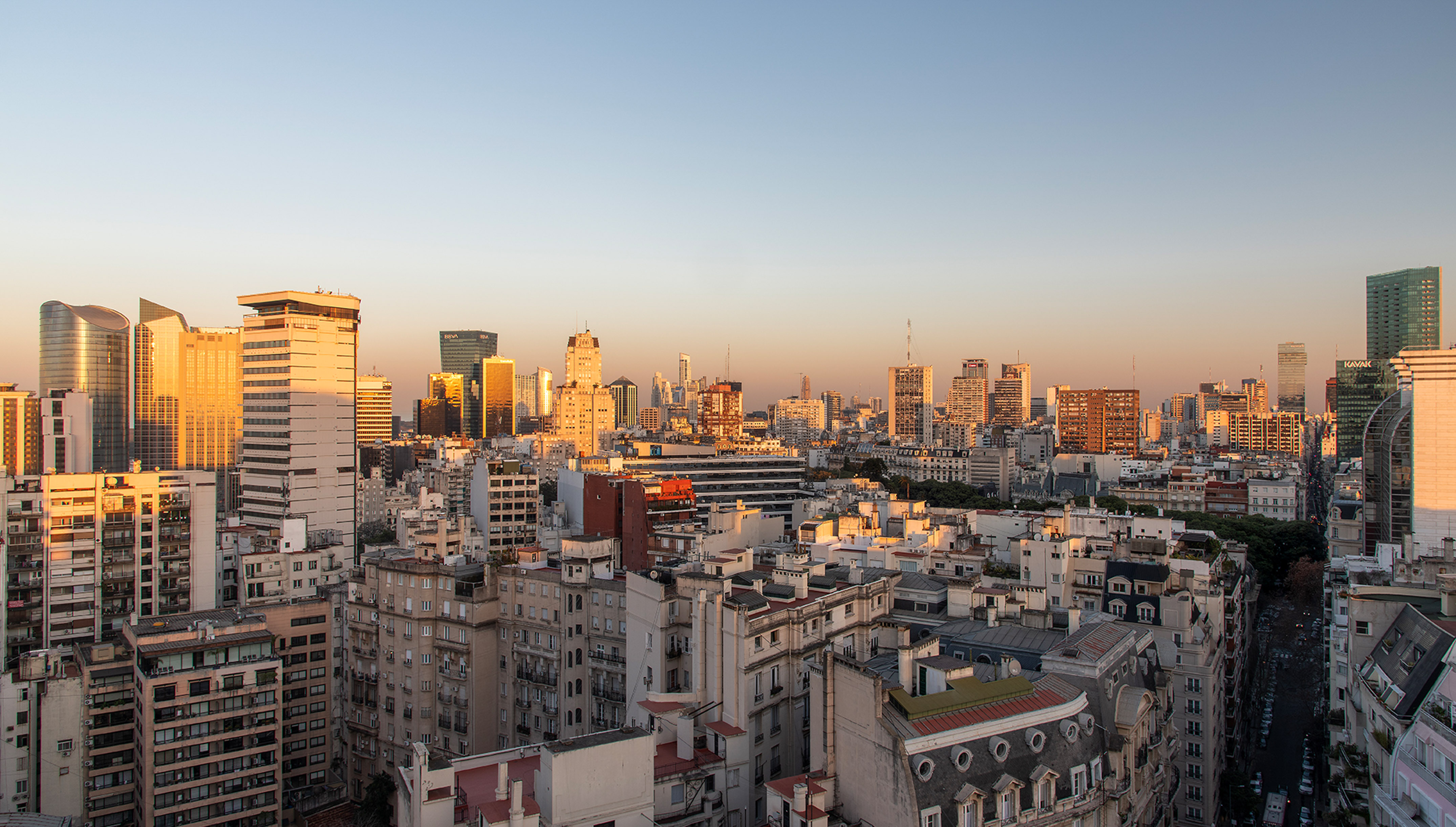 Buenos Aires skyline at sunset, with modern skyscrapers and residential buildings.
