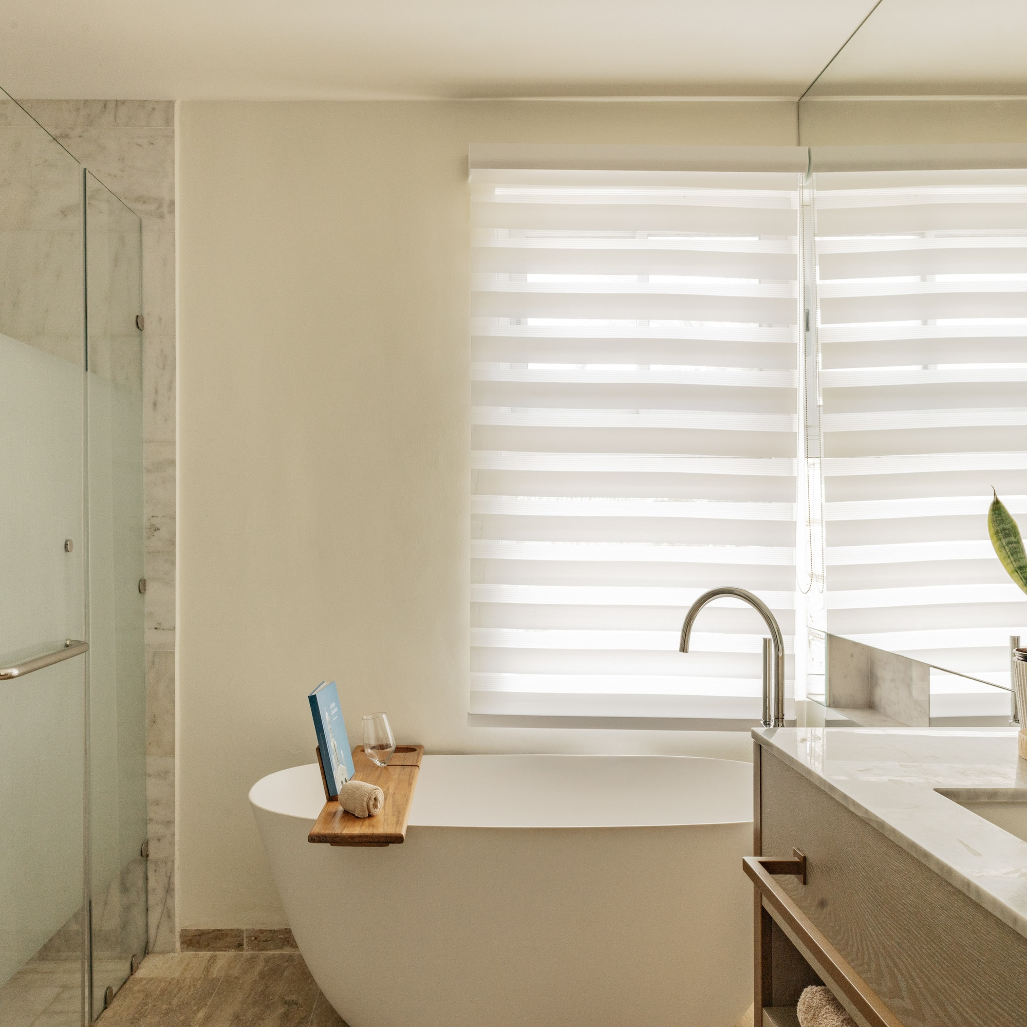 Modern luxury bathroom with freestanding tub, glass shower, and marble vanity.