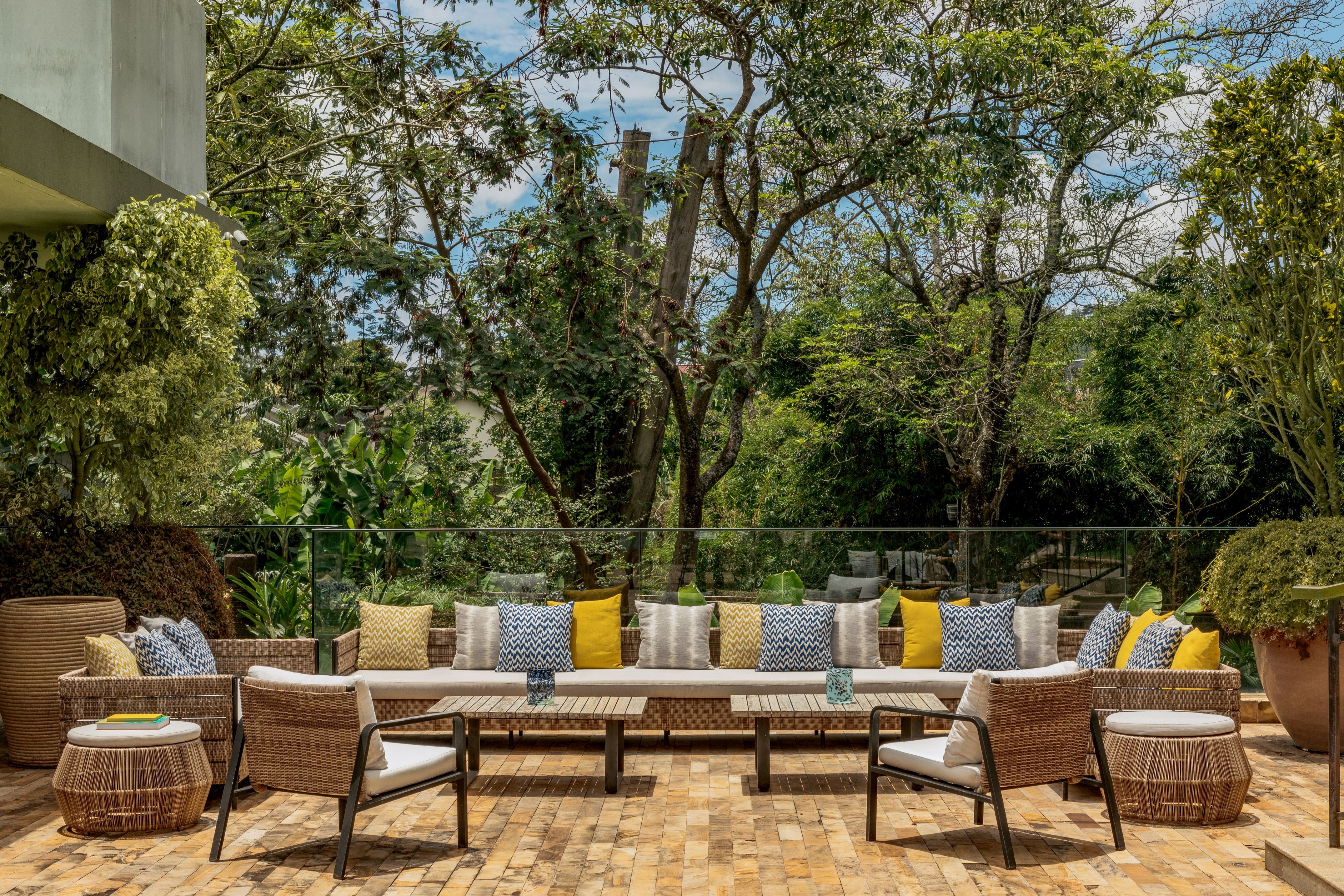 Outdoor lounge patio with wicker furniture and lush tropical garden.