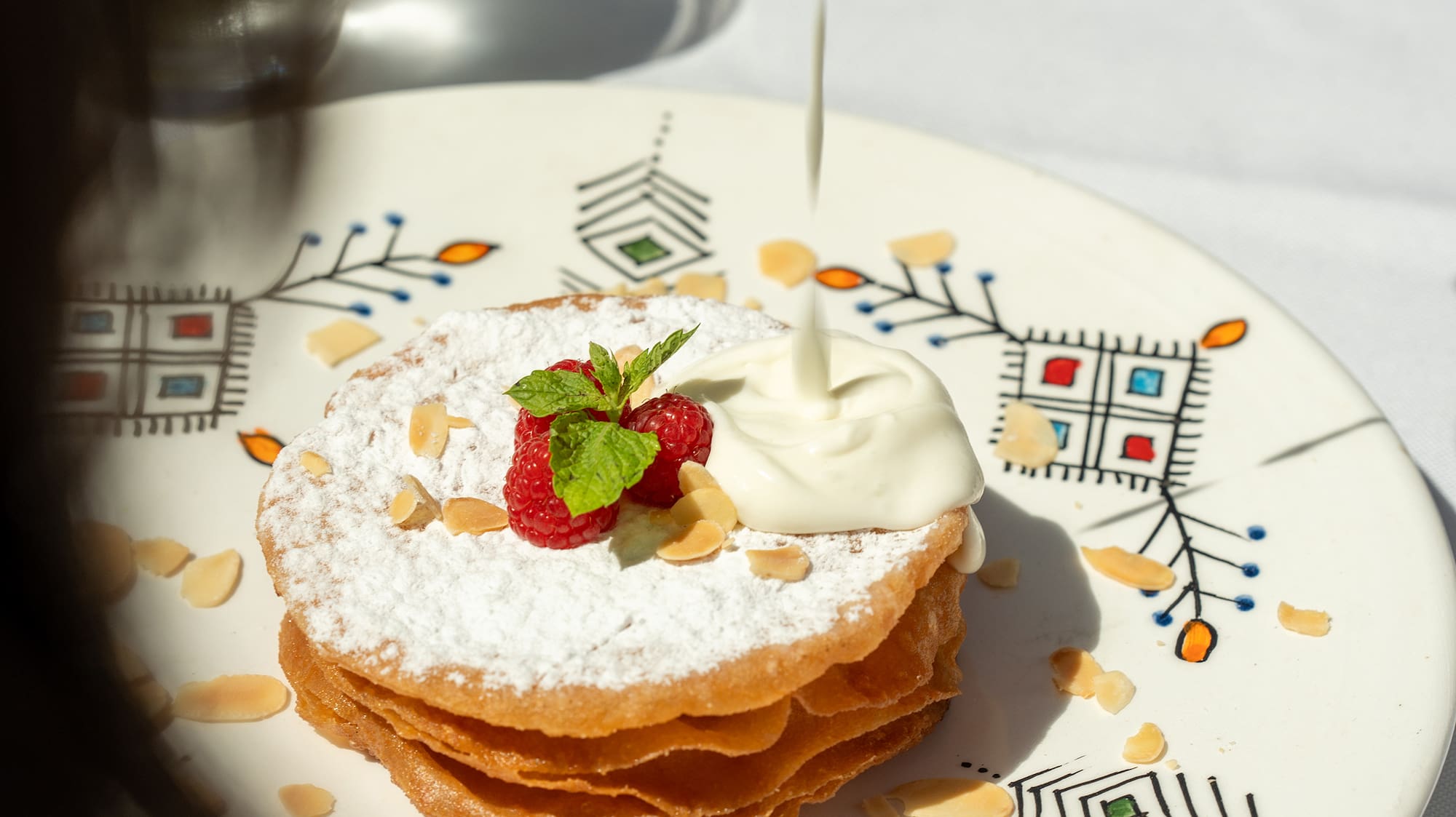 a plate of food with whipped cream and strawberries