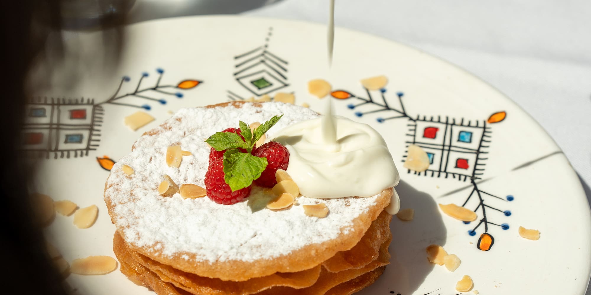 a plate of food with whipped cream and strawberries