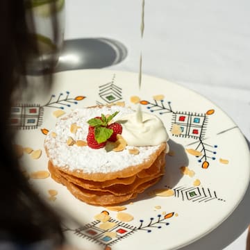 a plate of food with whipped cream and strawberries