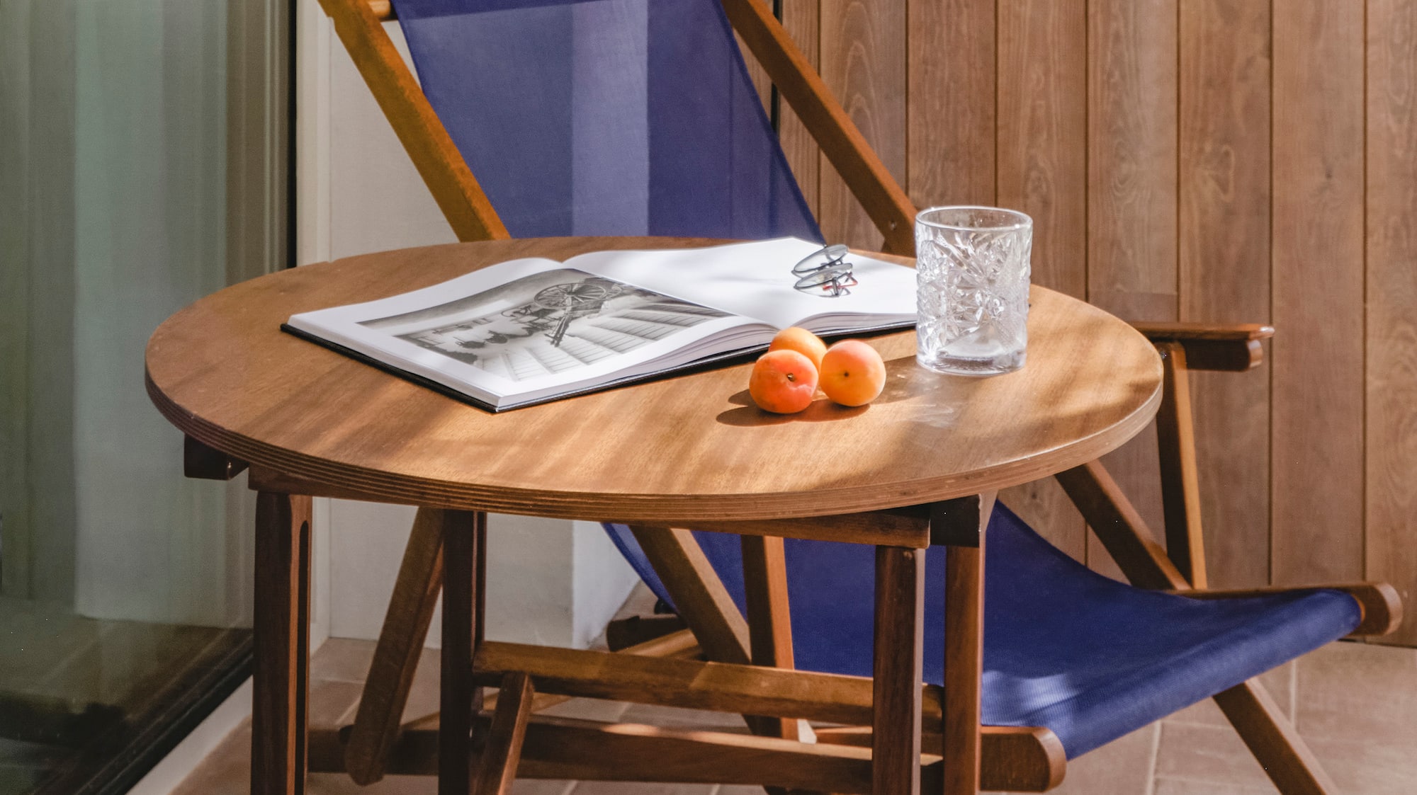 a chair and a table with a book and a lamp