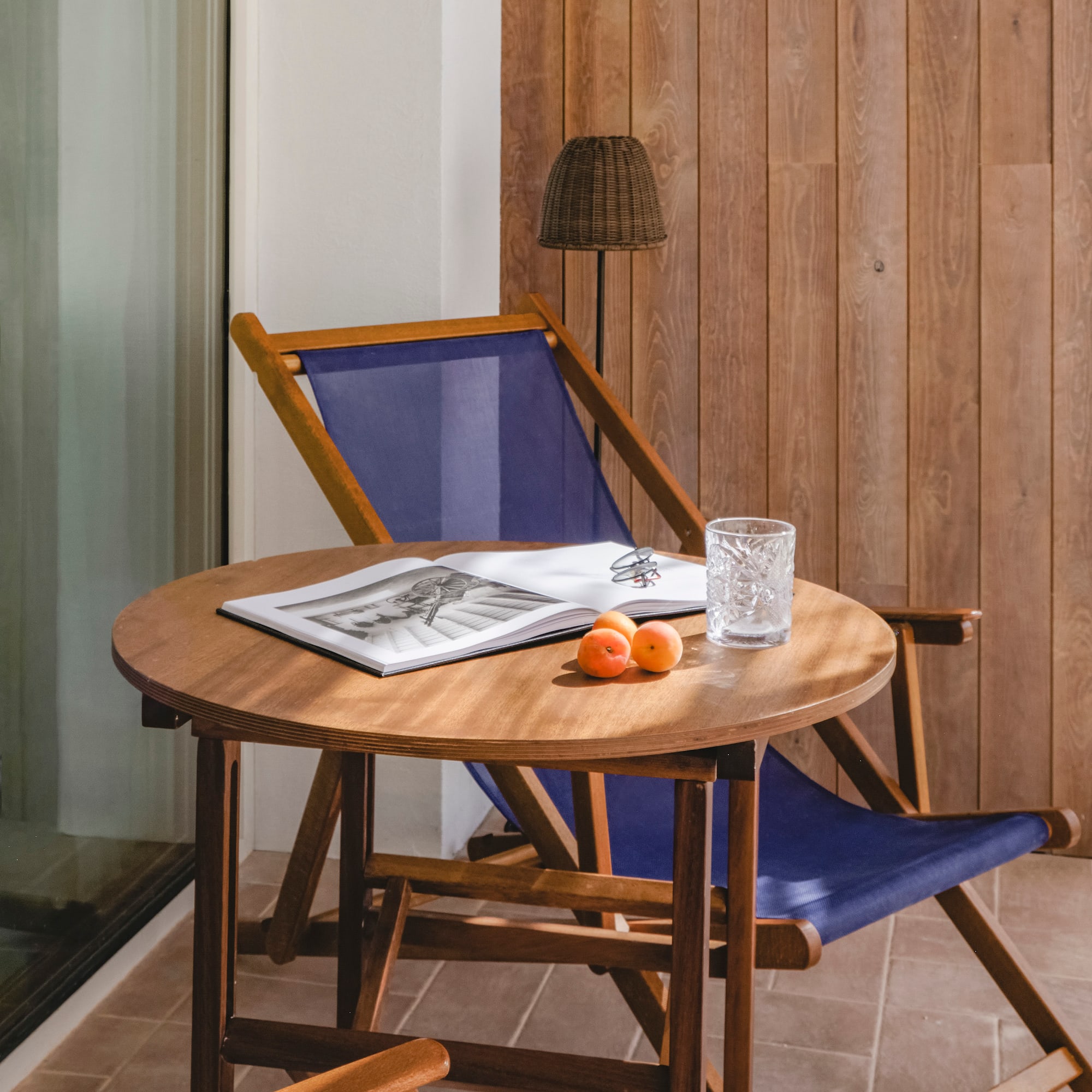 a chair and a table with a book and a lamp