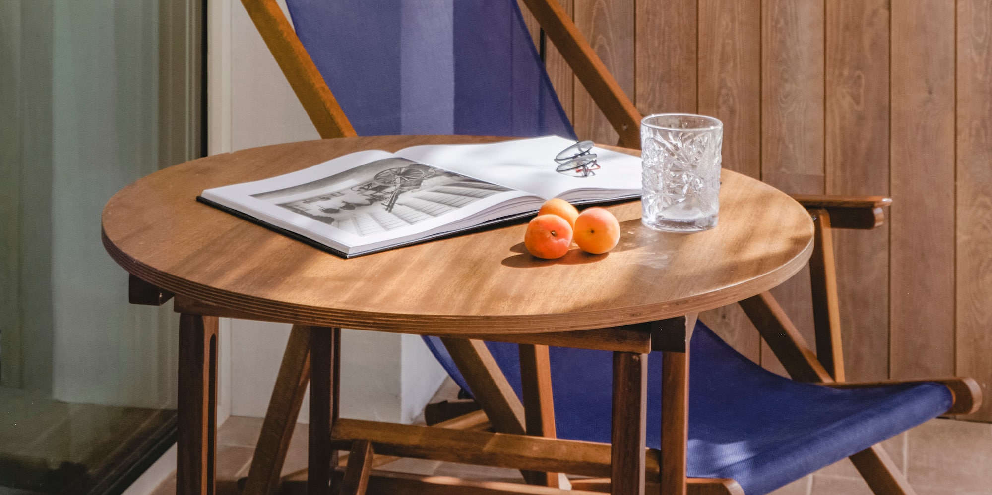 a chair and a table with a book and a lamp