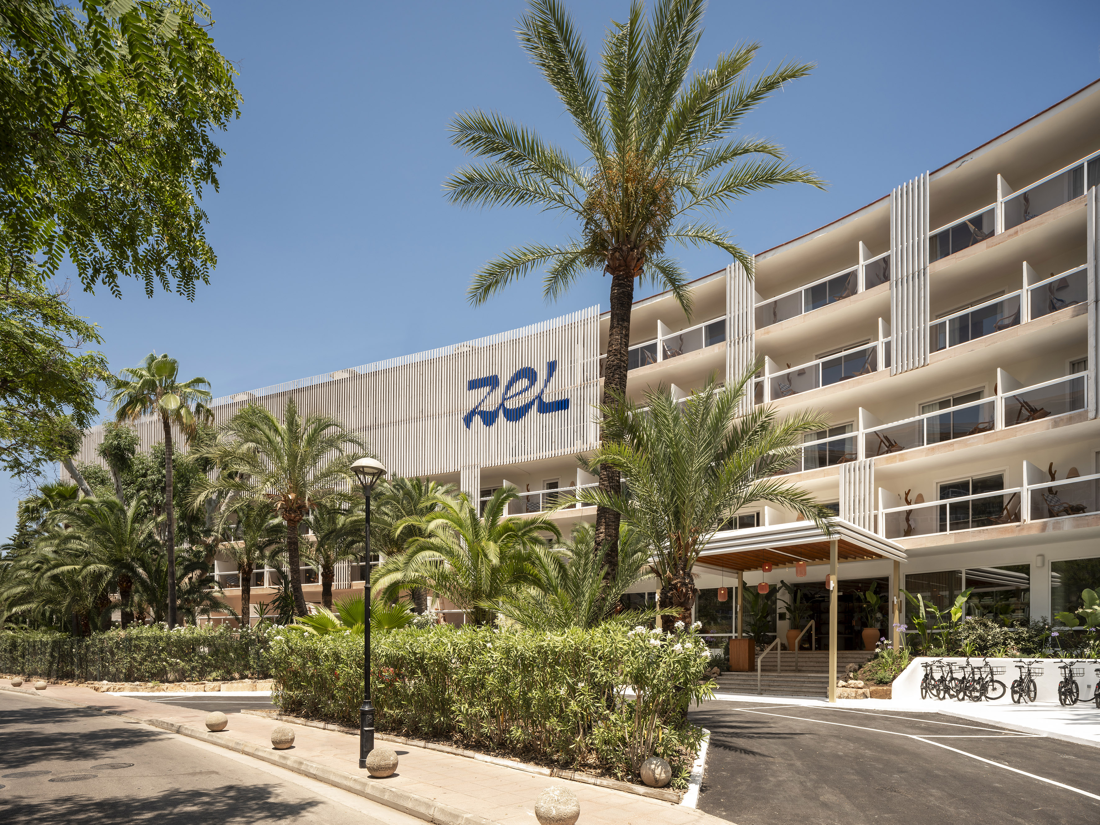 a building with palm trees and a road