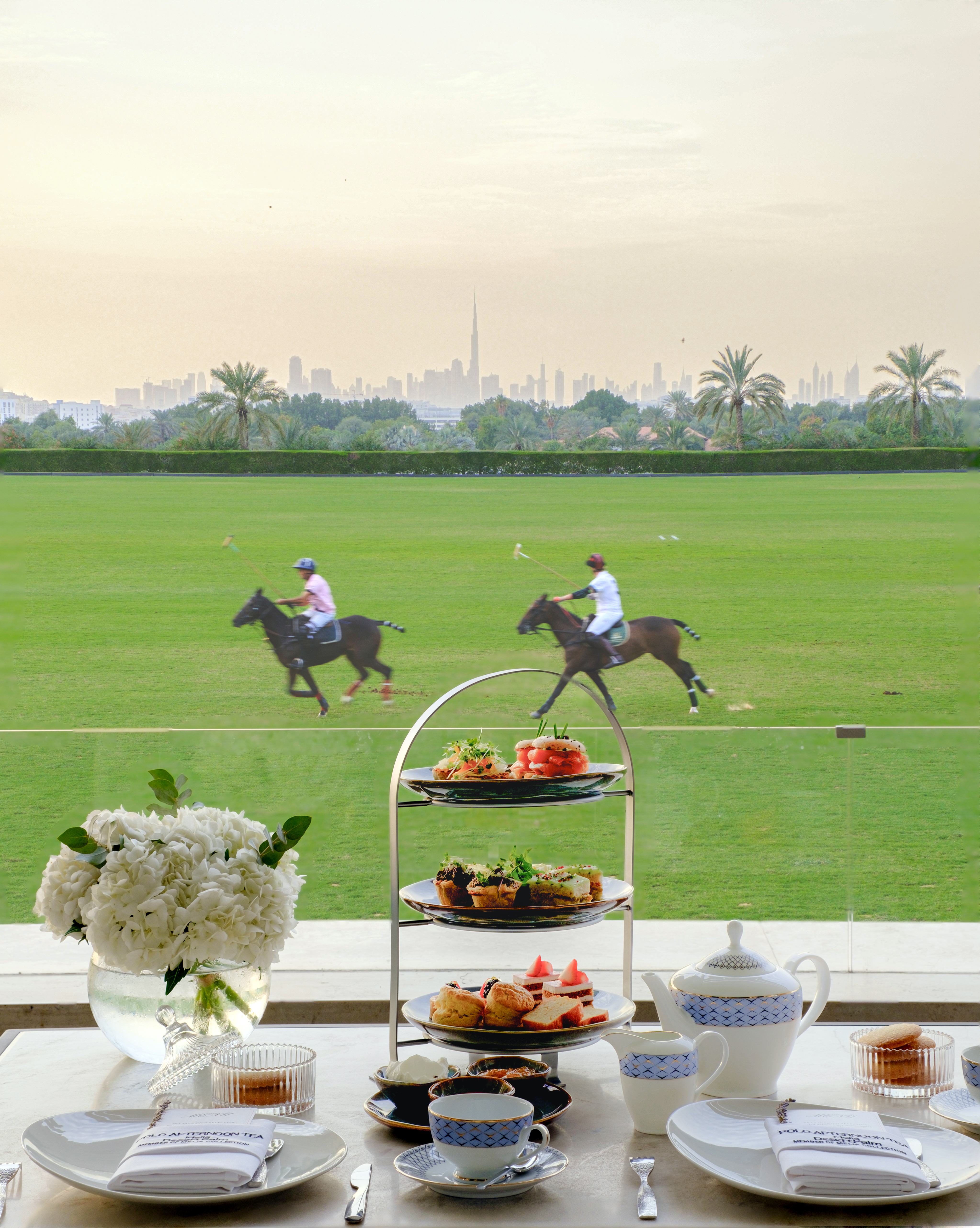 Afternoon tea overlooking Dubai polo match, Burj Khalifa cityscape.