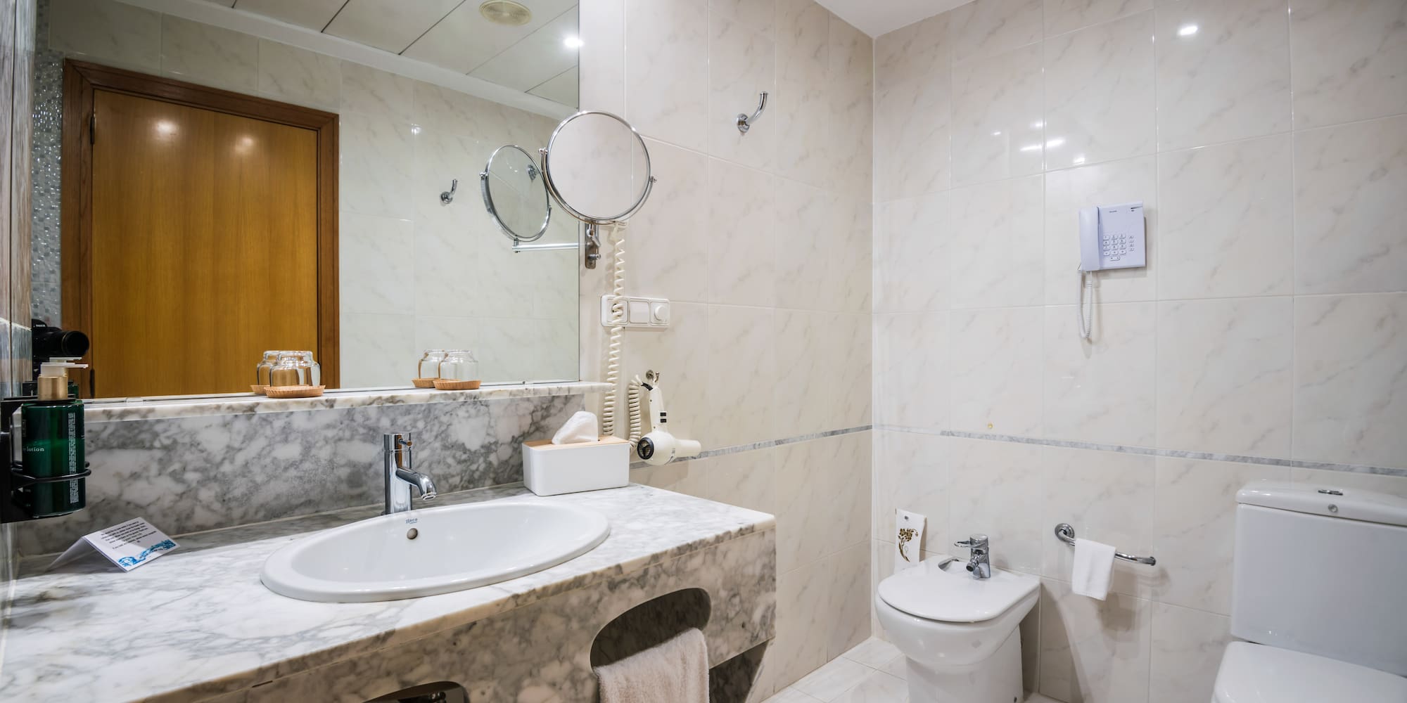 a bathroom with marble countertop and sink