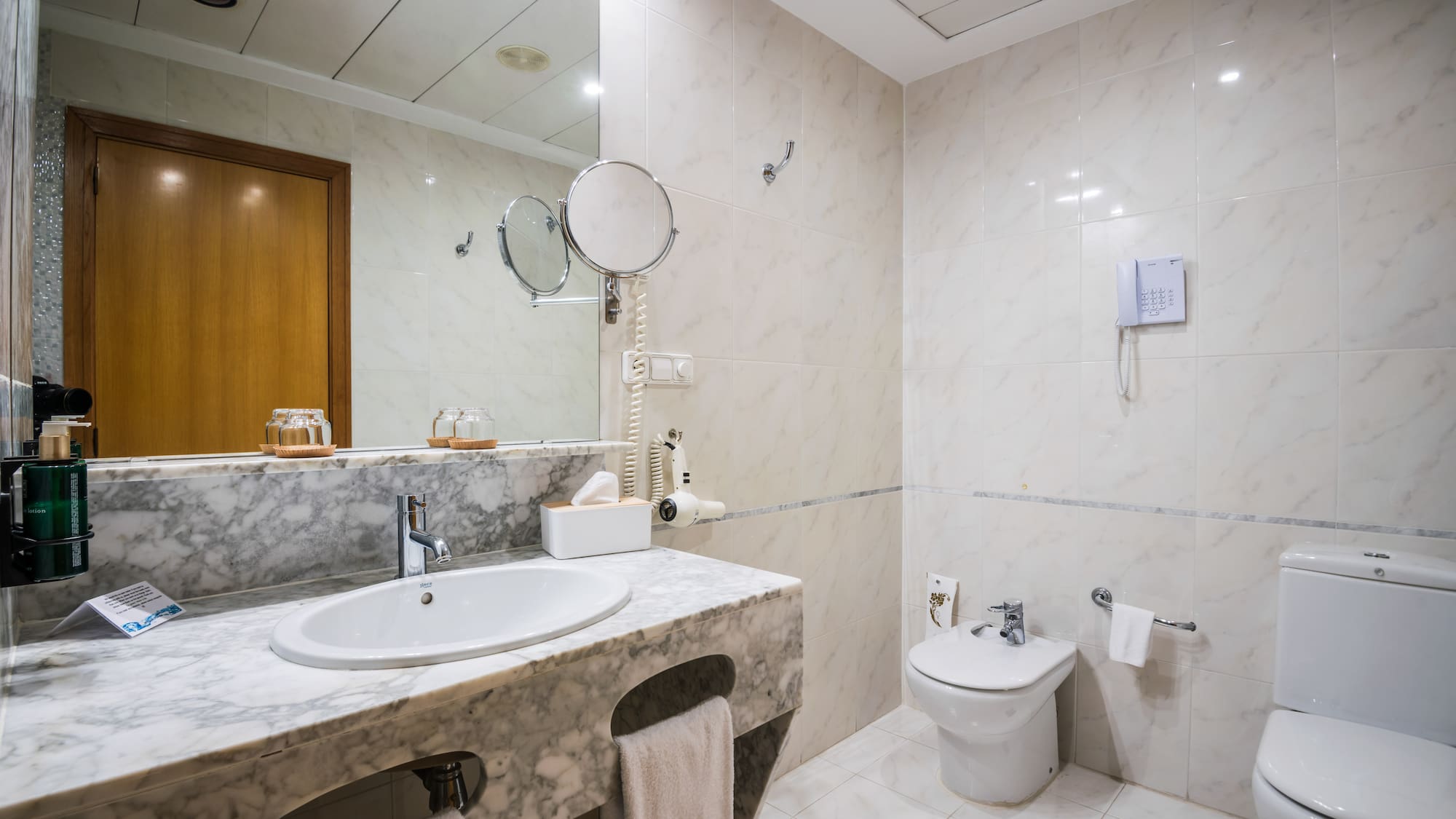 a bathroom with marble countertop and sink