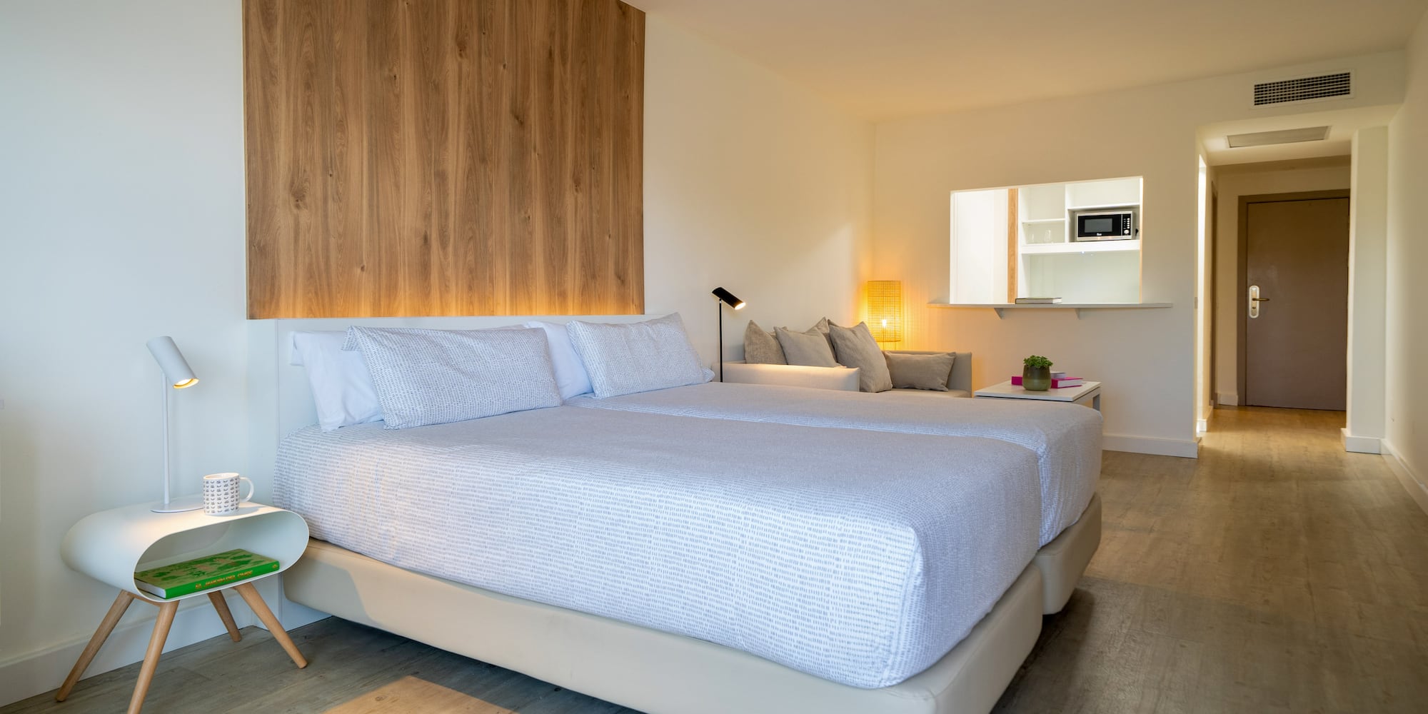 a room with two beds and a wood wall