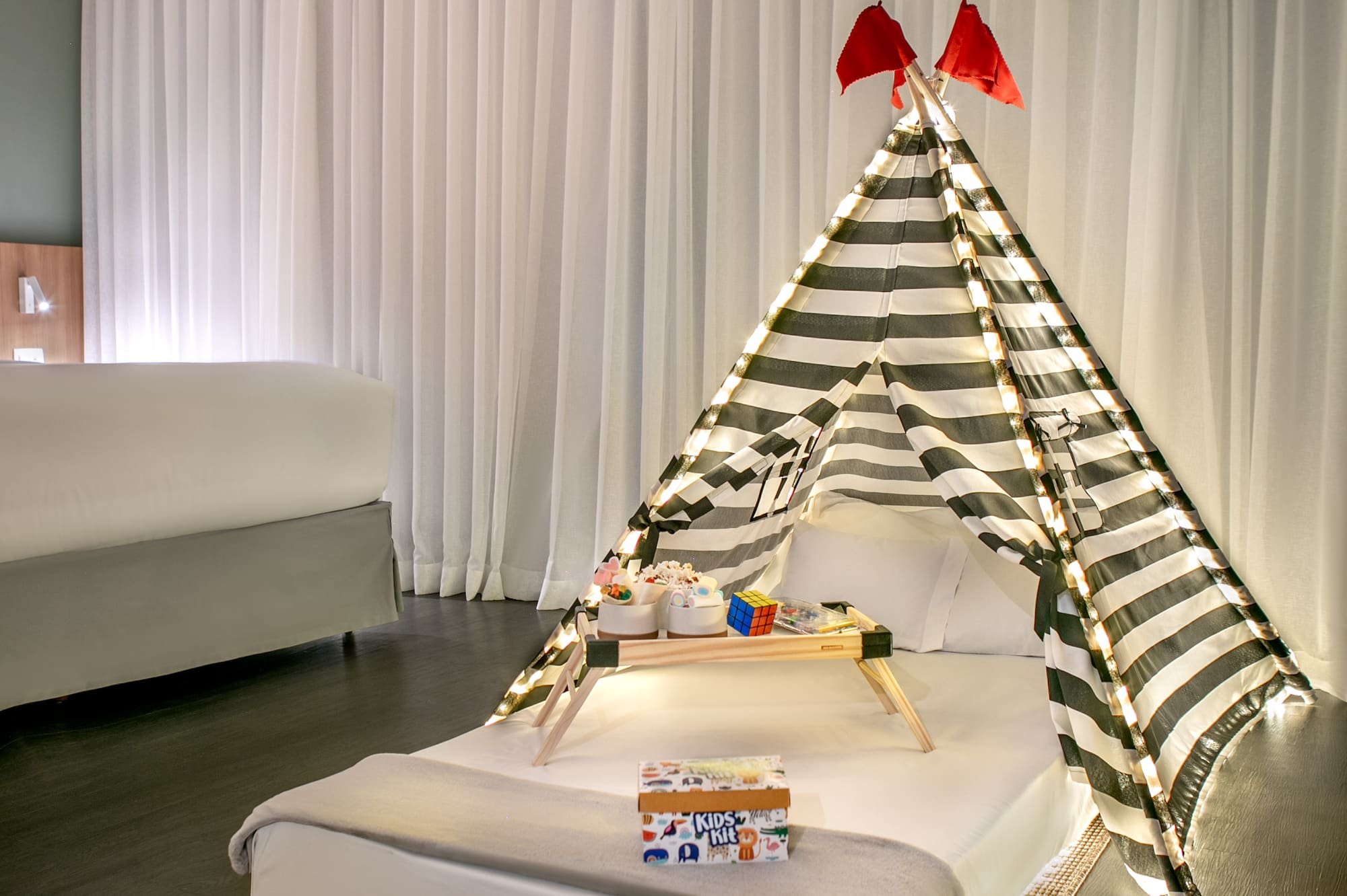 a bed with a tent and a tray of presents