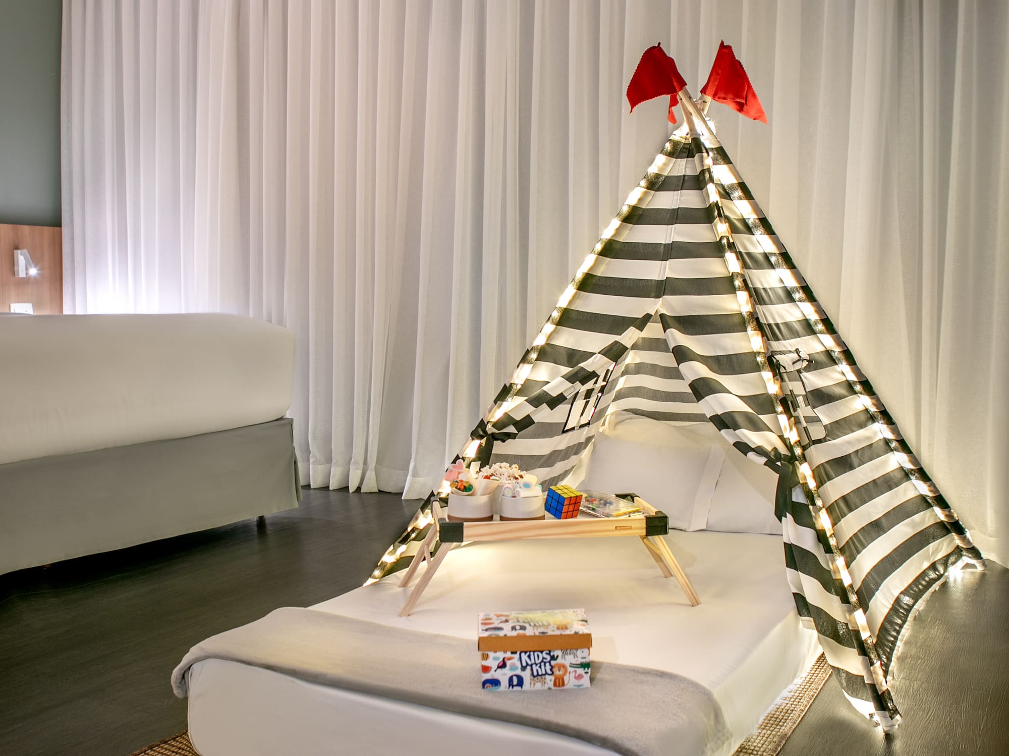 a bed with a tent and a tray of presents