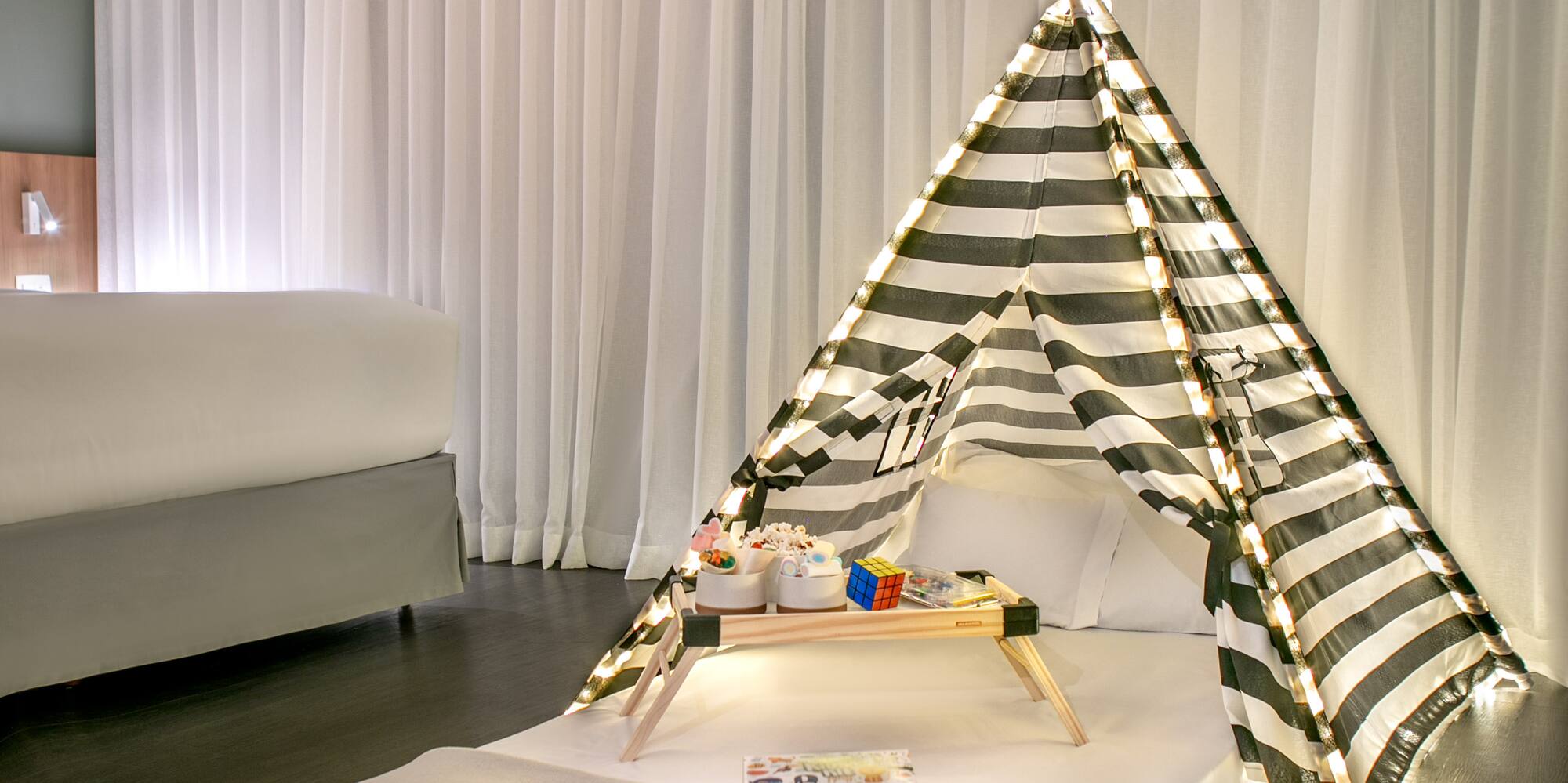 a bed with a tent and a tray of presents