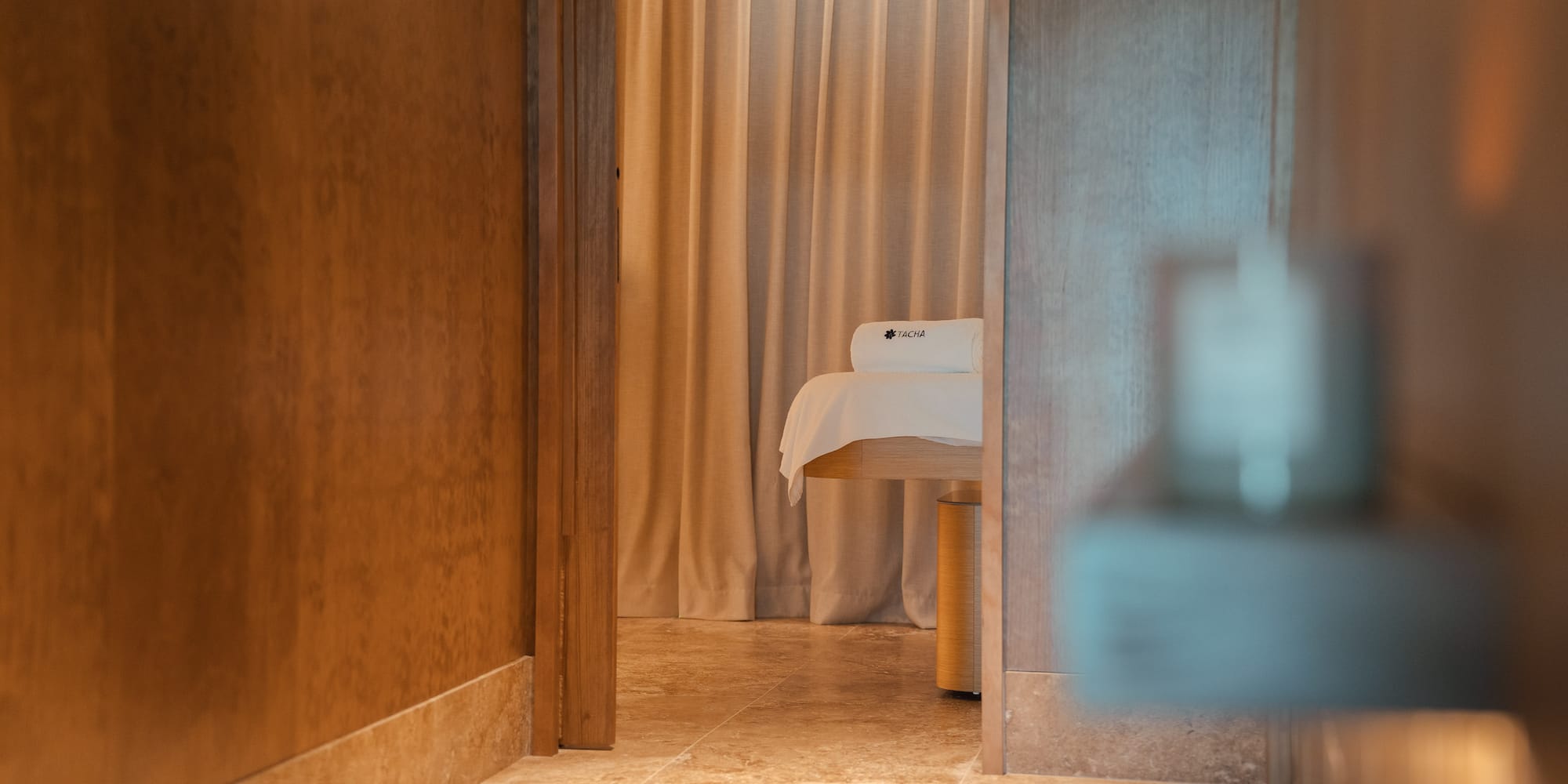 a room with a massage table and a curtain