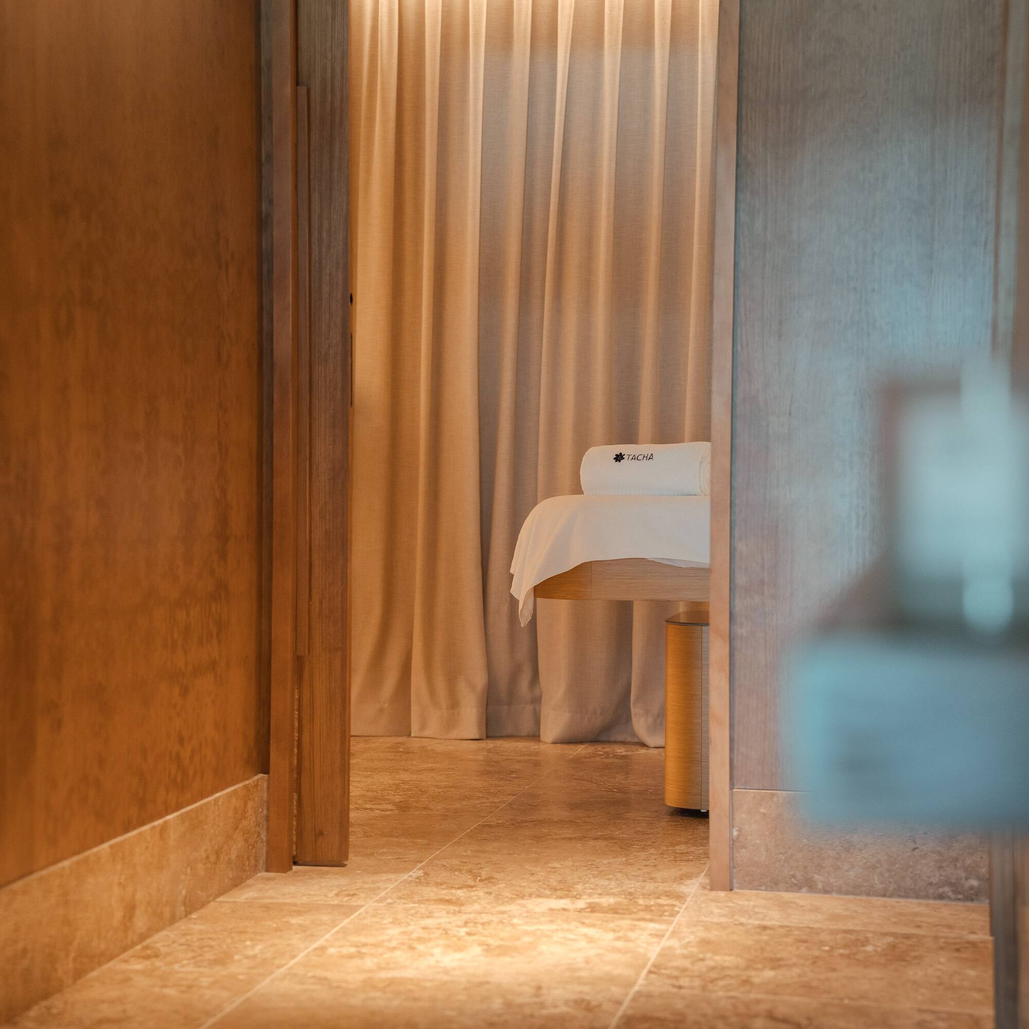 a room with a massage table and a curtain