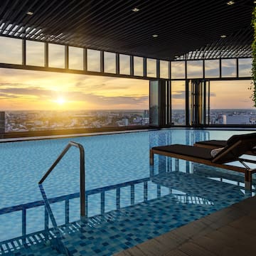 a pool with a view of a city and a sunset