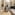 Modern bathroom with wood floor, green tiled walls, white tub, toilet, and sink.