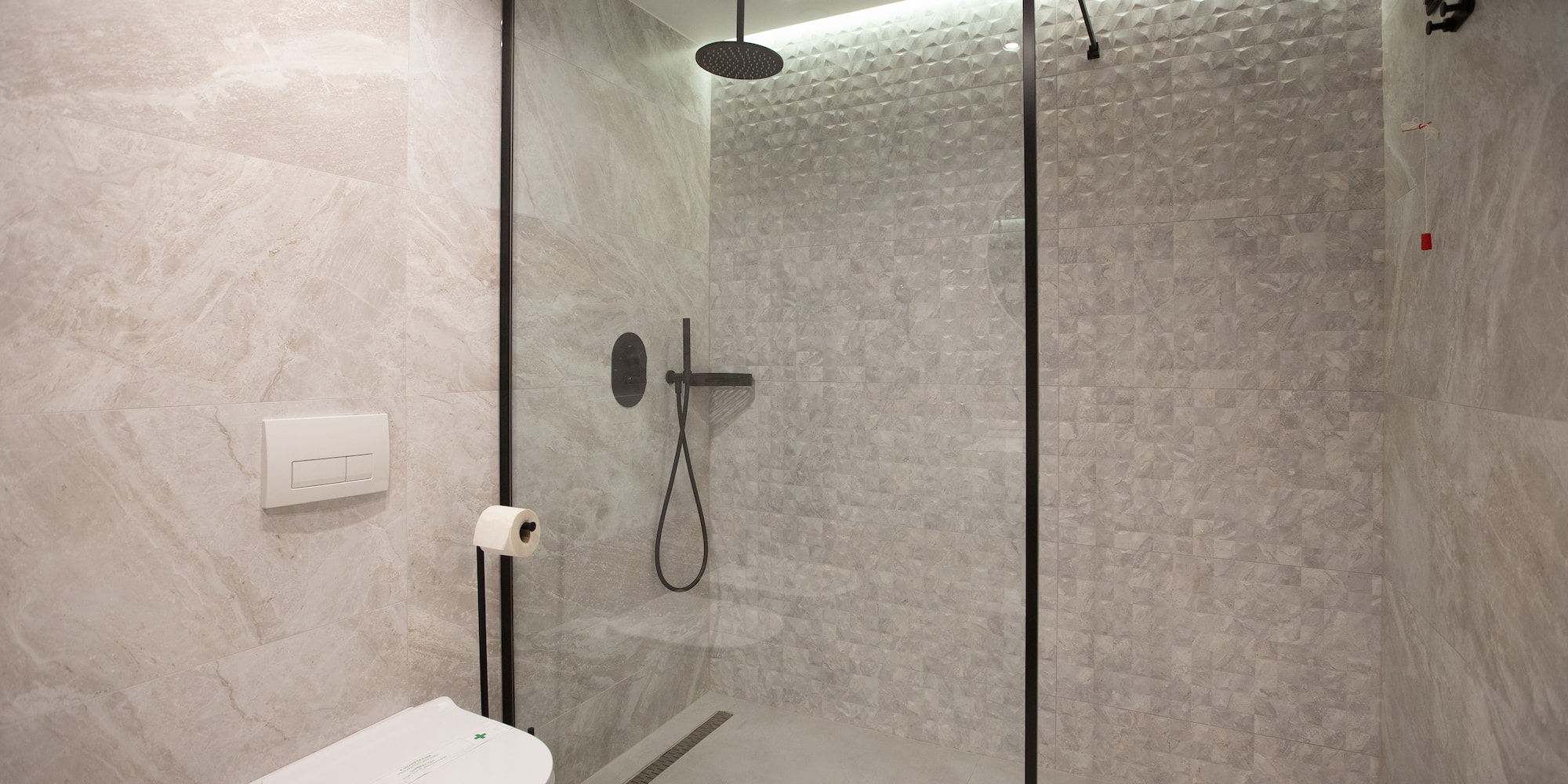 a shower with a toilet and a shower head