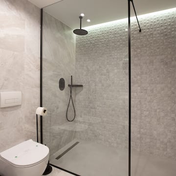 a shower with a toilet and a shower head