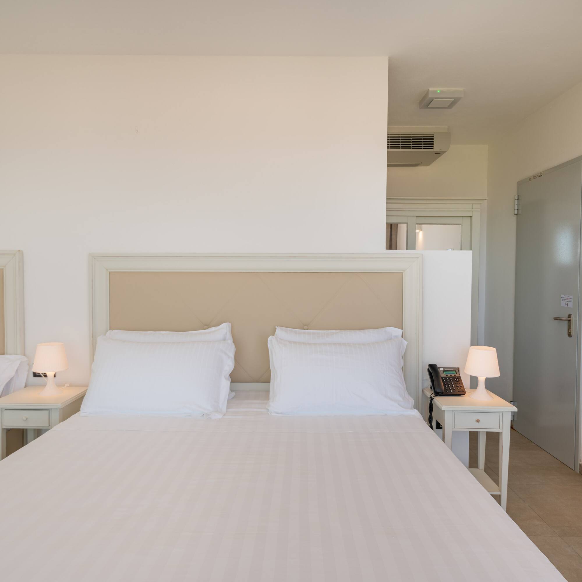 a bed with white sheets and pillows