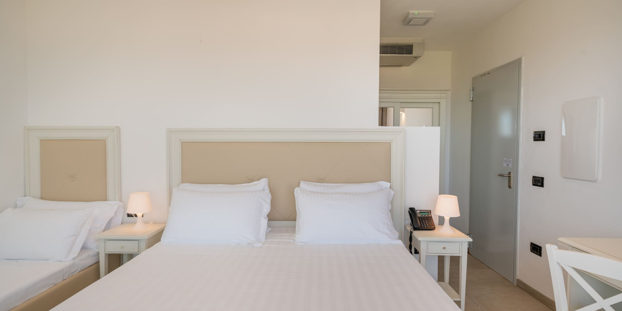 a bed with white sheets and pillows