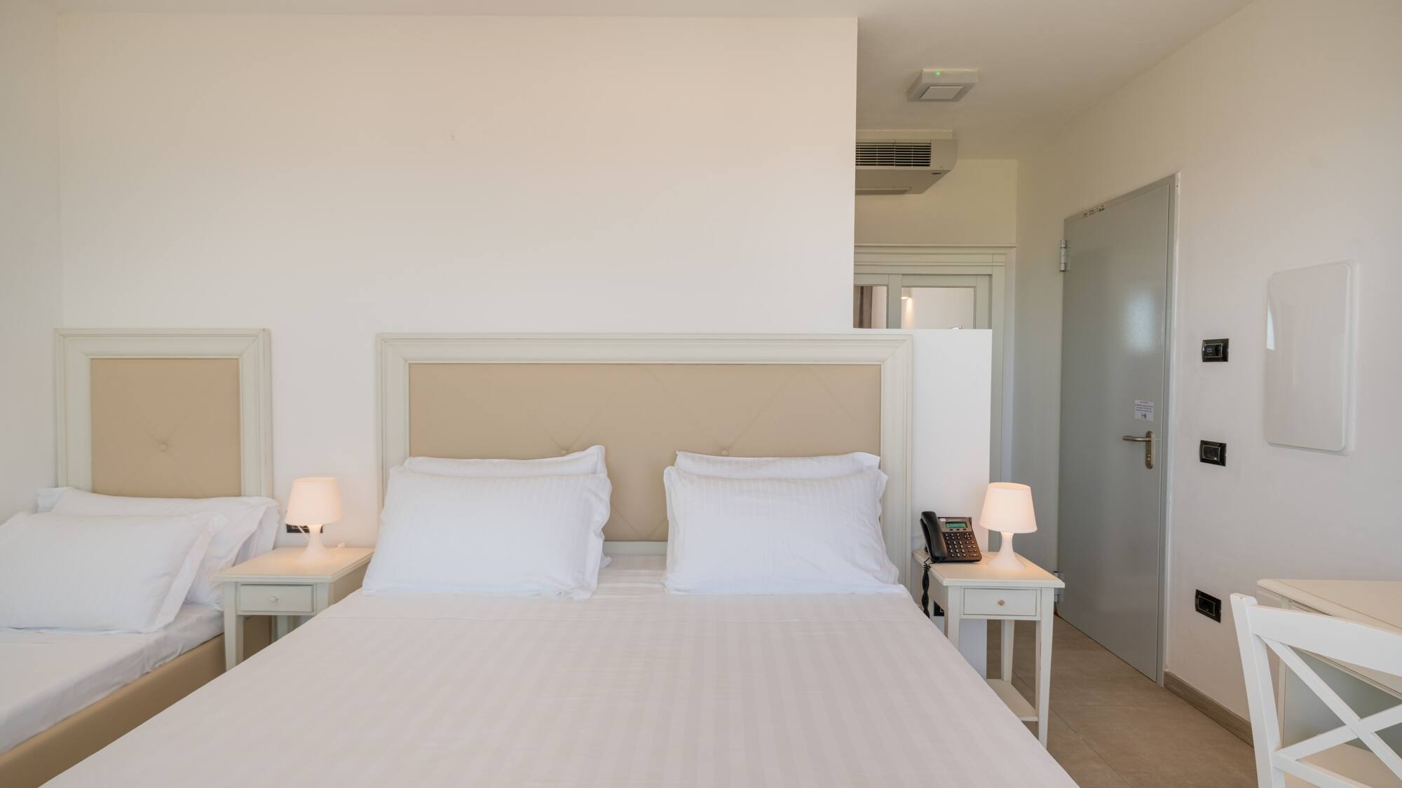 a bed with white sheets and pillows