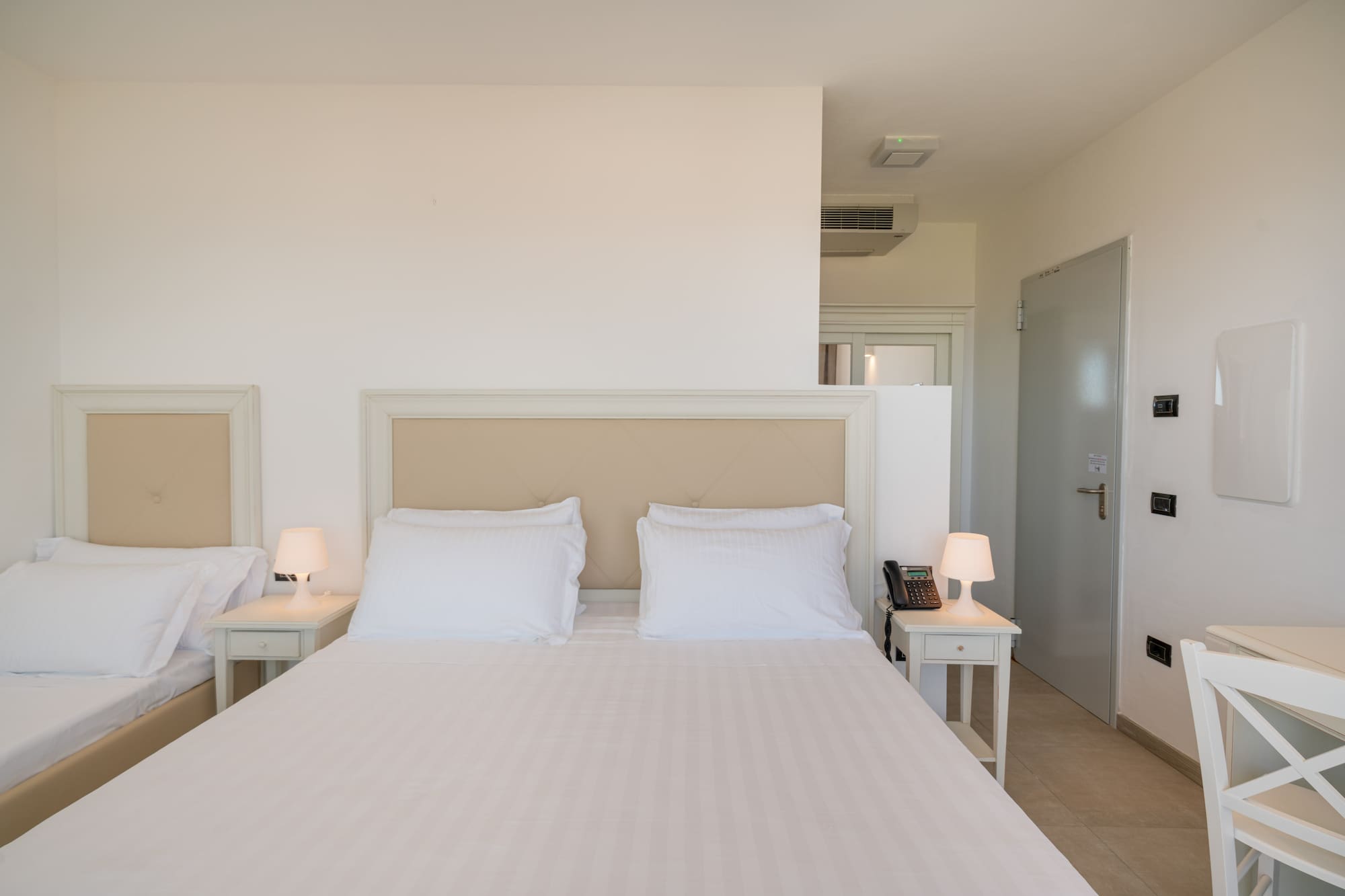 a bed with white sheets and pillows