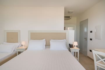 a bed with white sheets and pillows