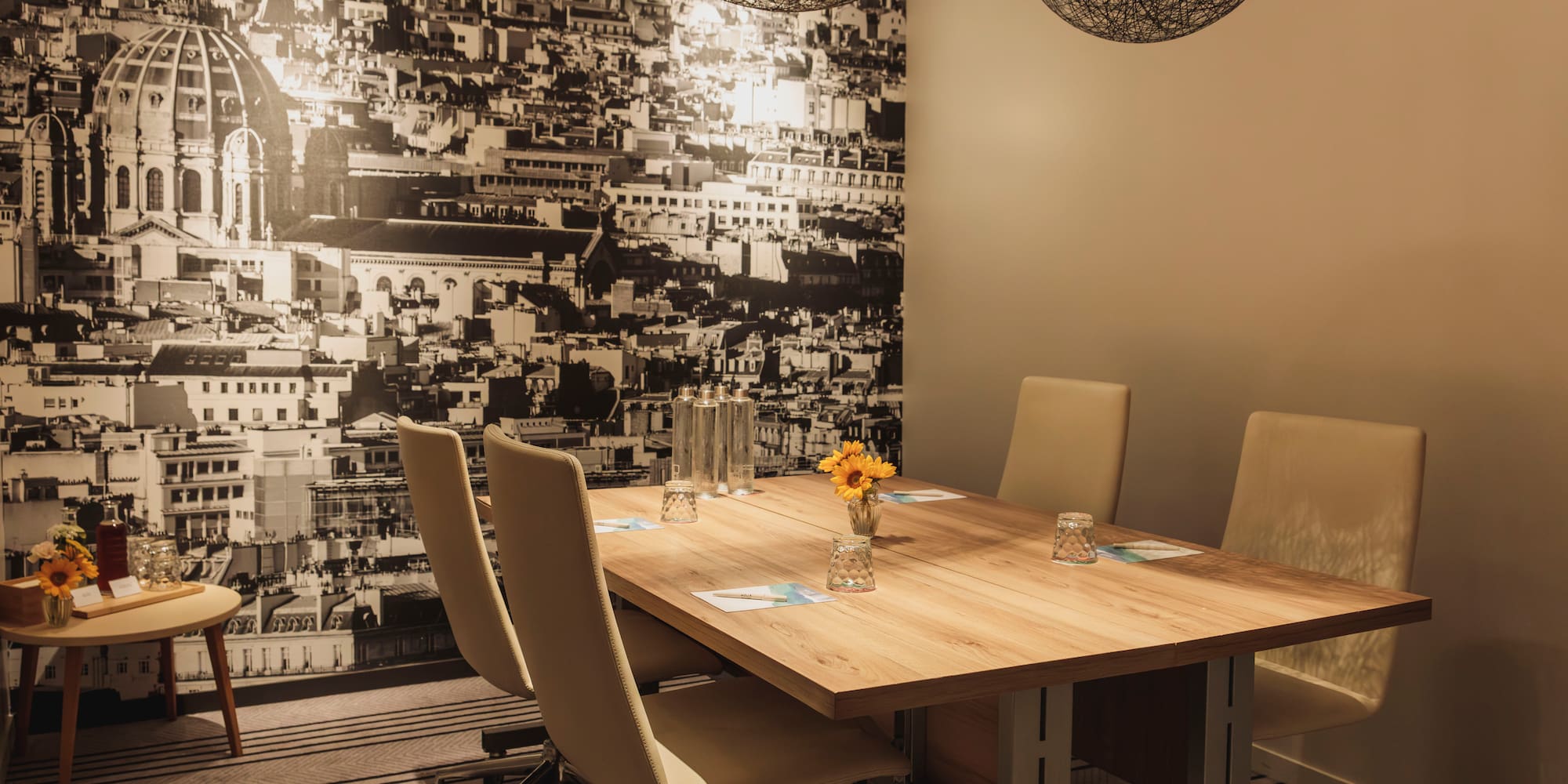 Conference room with cityscape mural, wooden table, and beige chairs.