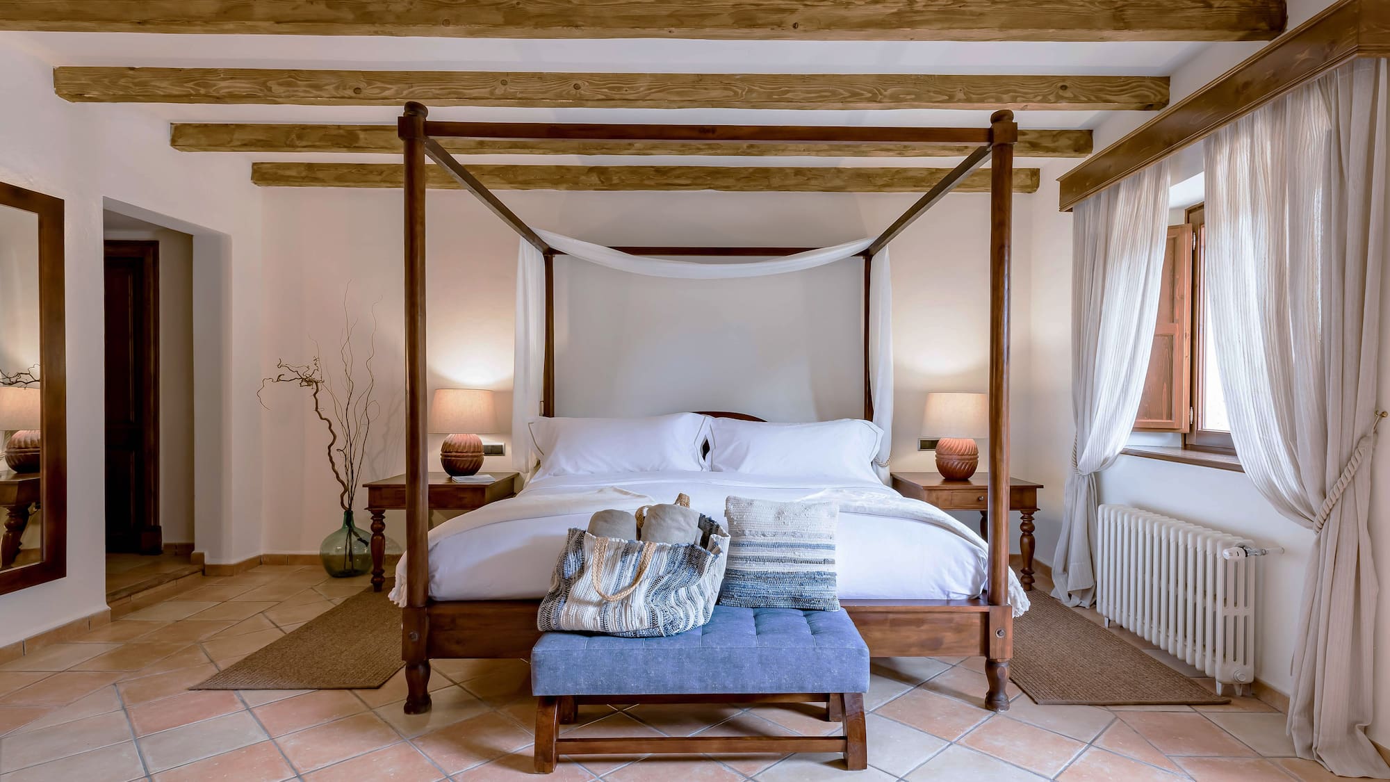 a bed with a canopy bed and a blue stool