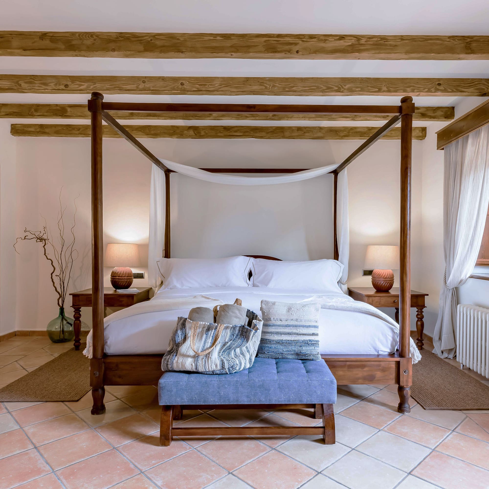 a bed with a canopy bed and a blue stool