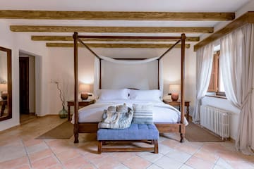 a bed with a canopy bed and a blue stool